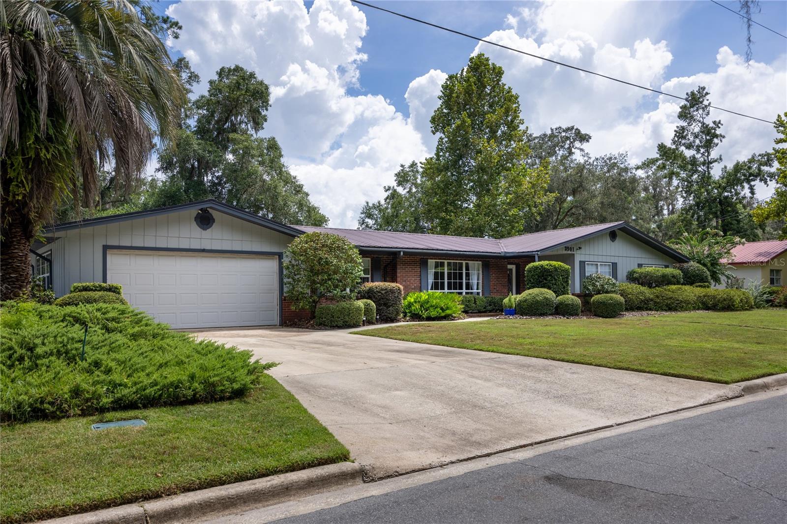 Vintage charm shines in this well maintained 3 bedroom, 2 bath traditional home on a large lot in The Valley. The bright formal living room off the foyer with floor to ceiling windows leads into the formal dining room, to the eat-in kitchen with plentiful cabinets, counter space, and pantry closet, and cozy family room with fireplace. Sliding doors from the family room and kitchen open to a spacious Florida room overlooking the patio, play area, and lush backyard with many camellias, orange trees, blueberry bushes, herb garden, and a pollinator garden. The oversized conditioned room off garage with laundry area at one end has enough additional space for exercise or yoga room, crafts, home office, music room, or your own creative ideas. Updated LVP flooring in main living areas and bedrooms.