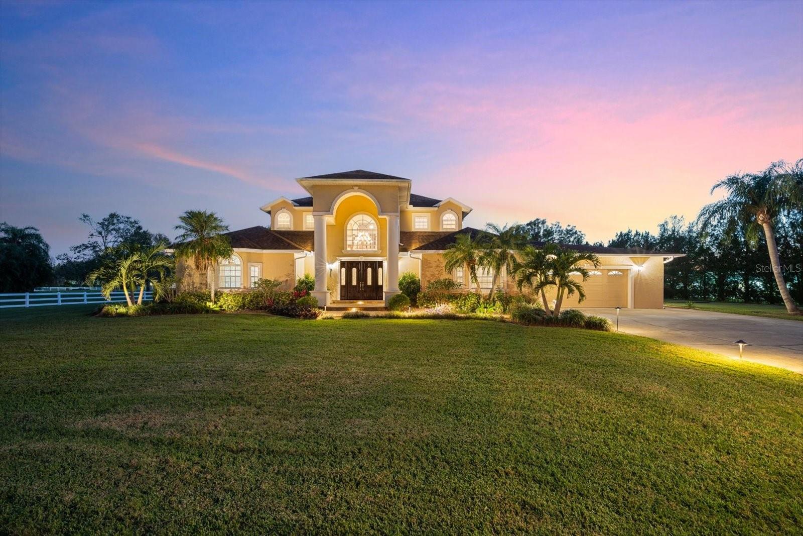 Welcome to where luxury and privacy meet at this custom-built home on a 5-acre gated estate located in the quaint subdivision of Deer Run, where there are only 8 private estates. As you drive through the gate and up the drive, you are met with tall cedar trees on the right and to the left are three large Royal Palm trees on an elevated, landscaped bed. The front and side yard are landscaped with various plants and palm trees all of which are stunningly illuminated at night. Upon entering through the mahogany front doors, you’ll be greeted by the grand spiral staircase to the second floor, one of two bedrooms with en suite located on the first floor and then enter the living room with Travertine tile floors, a fireplace and a perfect view of the pool through the sliding glass doors. Entertaining is a dream in the large kitchen with a gas cooktop in a center island with an overhead range hood, 2 ovens and large bar area for your guests to enjoy watching the chef in action. Need more room, no problem because the great room can accommodate a very large group with plenty of room to spare! From here, you can step out onto the lanai through French doors where the pool and hot tub are located. Imagine sipping your coffee in the hot tub in the mornings and looking out over your large yard that leads out to the lake. Or sip a glass of wine in the evening as the sun goes down and enjoy the illuminated landscape surrounding the lanai. It’s very common to see wildlife such as deer strolling through the yard both morning and evening. The owner’s suite is located on the other side of the first floor and provides the perfect place for relaxation beside your private fireplace. In the owner’s bathroom is a large shower, a jacuzzi tub, double vanities and double toilets. On the second floor is the third full bathroom and three bedrooms, each with access to a balcony that overlooks the pool and back yard. The fourth full bathroom is located off the back patio where it’s perfectly located for pool guests to use. A separate 40’ x 46’ garage with a 12,000-pound car lift is the perfect place for storing your extra cars, motorcycles, a golf cart or to let your inner creative side come to life in the workshop/studio area. This space is air conditioned with two 2-ton mini splits and a window unit in the back studio and has its own half bathroom. Behind the garage is where you can store your RV or boat in the 18’ x 40’ garage. The entire property is powered by solar panels that are placed on roof of the detached garage and RV garage. Seller has not received an electric bill since they've been installed and only pays the minimum monthly service fee. Located approximately 3.5 miles from I75 will make for an easy commute and is conveniently located close to Lakewood Ranch, UTC mall, Nathan Benderson Park, restaurants, and the famous Sarasota beaches.