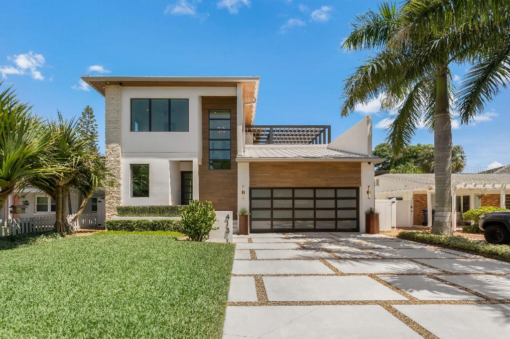 Stunning architectural design and exceptional use of materials and finishes combine to create this extraordinary Davis Islands home by BUILDeriors. No detail was overlooked in the design of this fully custom home perfectly situated on one of the quietest streets on Davis Islands. The exterior of the two-story home features natural limestone, tile, stucco, stained tongue & groove wood soffits, soffit lighting, built-in planters, metal roof, imperial marquee awning, and a custom pergola over the second floor deck. The interior of the home features 4 bedrooms, 5 full bathrooms, 1 half bathroom, 10’ ceilings, motorized window treatments, and designer tile & engineered hardwood flooring (diagonal pattern). Included on the first floor is an open concept chef’s kitchen, living room, dining room, butler’s pantry, walk-in pantry, guest bedroom suite, half bathroom and office. The chef’s kitchen features custom cabinets, JennAir appliances (48’ dual-fuel range, range hood, 48” of refrigeration / freezer, microwave drawer, dishwasher, steam oven, and espresso machine), ice maker, under counter wine refrigerator, quartz countertops and a quartz waterfall edge island. The living room has a natural limestone floating feature wall. The pool and lanai sit just off the living room and dining room separated by a wall of sliding glass doors allowing for true- indoor-outdoor living. The pool fire feature and sheer descent waterfalls create a wonderful focal point when dining with family and friends. The exterior lanai and pool deck feature marble pavers, a stained tongue & groove wood ceiling, recessed lighting, floor to ceiling tiled walls, and a custom louvered steel wall. The raised saltwater pool has an eye-catching micro glass mosaic all along the waterline, pool deck planter and fire / waterfall feature wall. The second floor of the home features the master suite, two additional bedroom suites, laundry room, and access to an outdoor deck with covered pergola and marble pavers. The master suite features an additional wall of sliding glass doors overlooking the pool and has dual master bathrooms with floor to ceiling marble mosaics and walk-in closets. The exterior yards have been professionally landscaped and maintained to allow for both privacy and lush tropical vistas. They feature mature specimen palms & trees along with gravel pathways and artificial grass covering the entire rear-yard. Other features of this property include a whole home generator, a whole home audio system including outside areas (pool area / lanai / garage / front entry), a camera system with full home perimeter coverage, alarm system, designer light fixtures, extensive landscape lighting (front, rear & side yard), 2-car garage with two motorized lifts for storage and bicycles, gas pool heater, tankless water heaters with continuous recirculation for instant hot water, multi-zoned AC system, built-in closet systems, and a six-zone irrigation system with vast coverage including the pool deck / lanai planter areas and second floor deck planter areas.