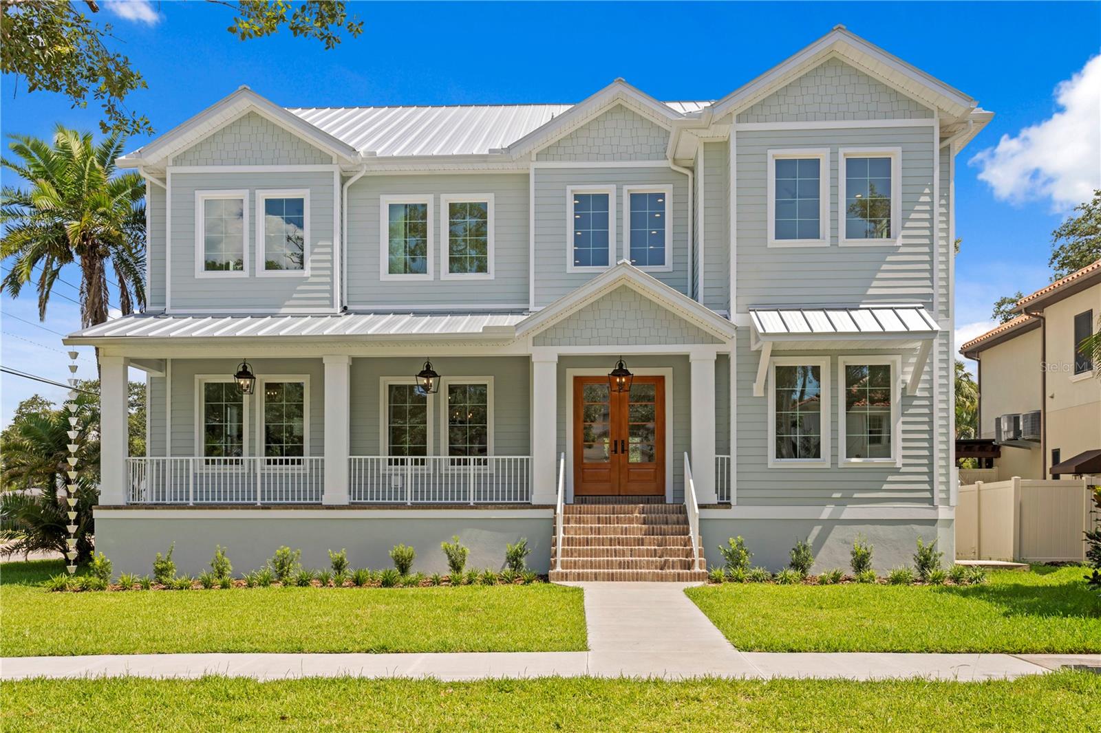 Under Construction. This two-story block construction, 5-bedroom, 6-bath, 4,988 sq. ft. custom residence sits on an oversized 75x120 corner lot in the heart of highly sought-after Virginia Park. This prime location offers walkable access to neighborhood shops and dining, with effortless connectivity to downtown Tampa, Tampa General Hospital, the Westshore District, International Plaza, and Tampa International Airport. Zoned for top-rated Mabry Elementary, Coleman Middle, and Plant High School, it combines modern living with timeless appeal. Crafted with an elevated foundation and built beyond standard code, the home features a standing seam metal roof, sealed building envelope with mechanical ventilation, Hardie exterior siding, and impact-rated high-efficiency windows/doors. 10-ft ceilings, 8-ft solid-core doors, and expansive rooms enhance the sense of scale, while abundant windows and glass doors flood the interiors with natural light and highlight wide-plank white oak flooring throughout. At the heart of the home, the chef’s kitchen showcases an oversized island, quartz counters, KitchenAid appliances including a 42" built-in refrigerator, 36" gas range, and microwave drawer. A walk-in pantry provides exceptional storage, while a butler’s pantry with wet bar and wine fridge opens to the formal dining room—ideal for entertaining. The open living area flows seamlessly to the outdoors, where a covered lanai with full summer kitchen overlooks a fully automated saltwater pool and spa with heat/cool, sun shelf, LED lighting, and shell stone decking. A dedicated pool bath with direct access adds thoughtful convenience. The first-floor primary suite is a private retreat featuring a tray ceiling, spa-inspired bath with soaking tub, walk-through shower with dual rain heads, dual vanities with makeup counter, and two custom walk-in closets with built-in drawers and shelving—her closet also includes a hookup for a stacked washer/dryer. Upstairs, four additional bedrooms include two guest suites with private baths and walk-in closets, and a Jack-and-Jill shared bath between the remaining two bedrooms. A large media/bonus room includes a full wet bar with dual-zone wine and beverage cooler, while an oversized laundry room with extensive cabinetry completes the second level. Every detail has been considered, from the dual HVAC systems with UV purification and fresh-air intake to the 2-car garage with soaring ceiling, Wi-Fi opener with camera, and generous storage potential. Additional features include a 400-amp electrical service, LED lighting throughout with under-cabinet and ambient accents, tankless gas water heaters, and a fully integrated smart-home package with hardwired security panels, surround-sound pre-wire with multiple speaker zones, direct fiber internet, Cat6 wiring, and a hardwired Eero system for seamless ultra-fast Wi-Fi across the property. All closets are finished with custom storage systems, while the exterior offers zoned irrigation and underground electric for a clean, sophisticated streetscape. The pool and outdoor living spaces are currently under construction, with renderings available to showcase the finished design. To further enhance the property, a privacy fence and landscaping are being installed along Manhattan, creating a secluded retreat that complements the home. With Southerlyn Homes’ commitment to never repeating a floor plan, this residence represents a truly one-of-a-kind opportunity in a highly sought-after South Tampa location.