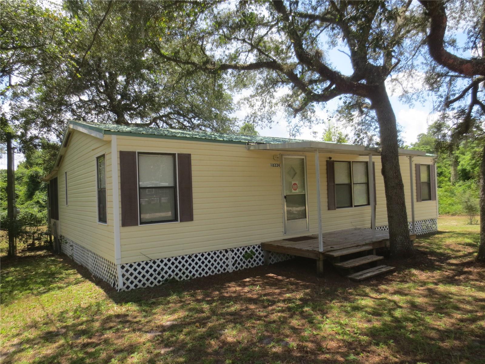 Come see this 3/2 Doublewide on a total of 1.22 acres! Property has 2 lots wooded and 2 lots cleared. Owner states: home has an artesian well, updates in the bathrooms and updated flooring in the living room. Home features a metal roof, fencing in the backyard, nice well/well pump enclosure, 12x6 open front deck and a 20x12 back porch that needs some cosmetic work. This home is move-in ready except for not currently have an outside A/C unit, so the sale must be cash for now. Make this home yours today!