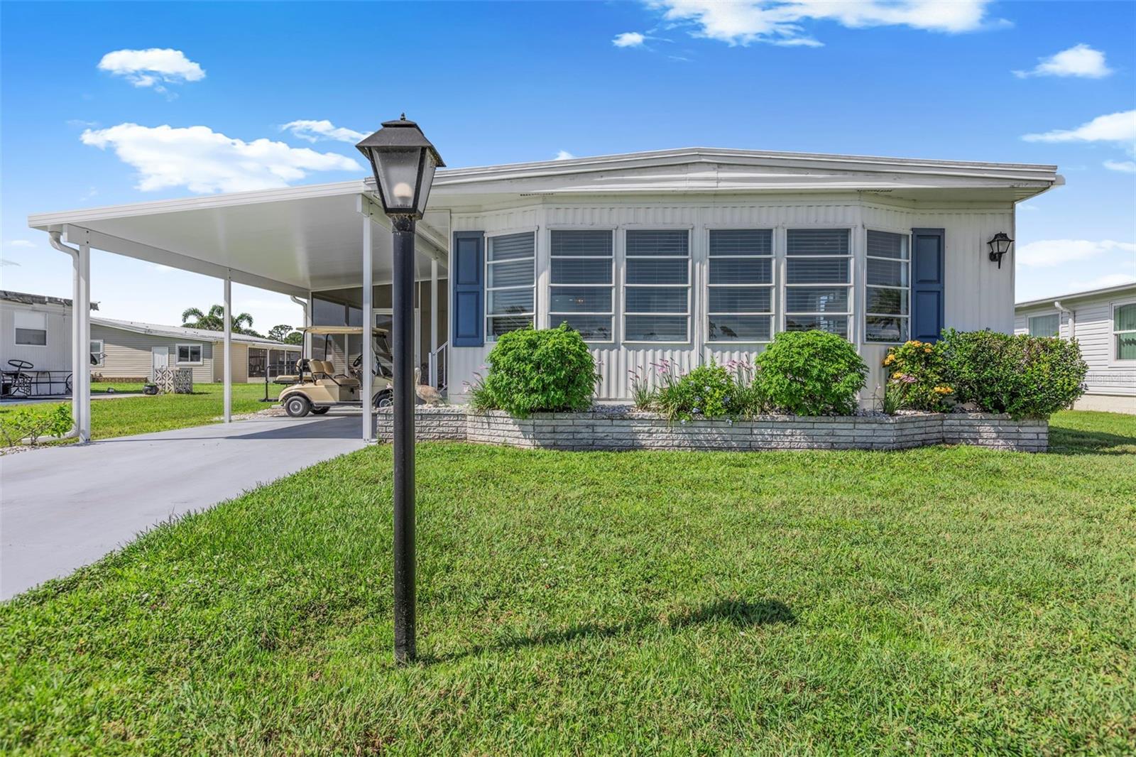 This remarkable 2-bedroom, 2-bathroom home invites you to experience breathtaking lake views that inspire tranquility. The circular kitchen, with its abundant cabinet space, dining area, and pass-through window, connects to the front Florida room, allowing you to soak in stunning vistas of the water. The formal dining room harmoniously flows into the Florida room and opens to the newly constructed carport, creating effortless access to the newly screened lanai. In the primary bedroom, a spacious walk-in closet awaits, while the primary bathroom features a stylish vanity and a walk-in shower designed for relaxation. The guest bedroom also offers a generous walk-in closet, complemented by a guest bathroom that includes a vanity, tub, shower, and a modern new commode. With recent updates, including a brand-new carport and tiled, screened lanai completed in 2023, a new roof installed in 2024, and luxury vinyl flooring with new subfloors added in 2023, this home embraces modern living. The utility room is equipped with a washer, dryer, and ample storage space. Offered “turnkey,” this home even includes your very own golf cart, ready to inspire new adventures! Discover the enchanting community of La Casa, where 974 stunning homes are elegantly nestled among a tapestry of native trees, offering a serene escape surrounded by spacious common areas and eight picturesque lakes. Our generous lots average an impressive 60 by 80 feet, providing ample space for your dream home. Perfectly situated between Sarasota and Fort Myers, La Casa embodies the ultimate lifestyle on Florida’s Gulf Coast—a true boaters paradise with direct access to the breathtaking Gulf of Mexico. Enjoy the convenience of nearby shopping, exciting sightseeing, world-class golfing, and abundant fishing and boating opportunities, all while indulging in the rich culture and refined elegance that Southwest Florida is celebrated for. As you immerse yourself in the warmth of Southwest Florida’s winters, you’ll find yourself in a relaxed and unhurried atmosphere, far removed from the hustle and bustle of the east coast. Our community is adorned with lush, mature landscaping that reflects the loving care both residents and management dedicate to preserving its beauty. At La Casa, you’ll discover some of the finest pools in the area. Our crowning jewel is a magnificent 40 by 60-foot swimming pool, maintained at a perfectly inviting 87 degrees. Just a short stroll away, you’ll find our cozy 20 by 40-foot pool, nestled charmingly between the clubhouse and the Activity Building. Both pools feature adjacent hot tubs, ideal for unwinding after a refreshing day of golf or an invigorating game of tennis. Stay connected while basking in the sun with our complimentary wireless Internet (Wi-Fi), available at the Clubhouse, Activity Building, and Recreation Hall. Whether you’re catching some rays or catching up on emails, La Casa has it all. Does this sound appealing? La Casa is not just a community; it’s a welcoming family-friendly haven.