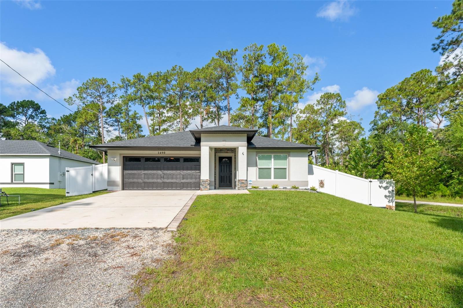 **This house comes with a REDUCED RATE through the seller's preferred lender. This is a lender-paid rate buydown that reduces the buyer's interest rate and monthly payment.** Welcome to your Florida oasis! Nestled on a spacious corner lot of over a quarter acre, this beautifully updated 3-bedroom, 2-bath home offers nearly 1,600 sq ft of stylish living space—complete with a screened-in pool and a fully fenced vinyl backyard. Step inside and be greeted by soaring vaulted ceilings, an open-concept layout, and easy-care tile flooring throughout. Two bright bedrooms with built-in closets are located at the front of the home, along with a full bathroom featuring a quartz countertop and a tub/shower combo—perfect for guests or family. Down the hall, the heart of the home awaits. The open living and dining area is light, airy, and flows seamlessly into the modern kitchen, which boasts sleek quartz countertops, gray cabinetry, and stainless steel appliances. Just off the kitchen, you’ll find a convenient laundry room for added ease. At the rear of the home, the private primary suite offers a serene retreat with a luxurious en-suite bathroom featuring dual sinks, a floor-to-ceiling tiled walk-in shower, and stylish matching finishes. Step outside to your own backyard paradise—a tranquil, screened-in in-ground pool (installed in 2024) perfect for year-round enjoyment, with a generous grassy area beyond that’s ready for your personal touch—garden, firepit, play area, or all of the above! Recent upgrades include a water filtration and softener system (2023), a hurricane-proof garage door (2024), a stunning stone addition to the entryway (2024), new gutters with gutter guards (2024), and the fully fenced backyard with durable vinyl fencing. Located in beautiful DeLand, this home combines modern upgrades with comfortable living—inside and out. Don’t miss your chance to make this slice of Florida paradise yours!