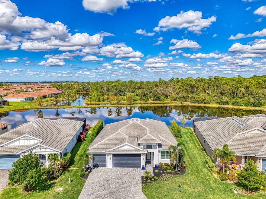 Experience the essence of refined living in this pristine custom home perfectly positioned on a premier lakefront, oversized, lot in Venice Woodlands. Embrace the warm welcome, serene surroundings and captivating views that define this exceptional residence and community. Presented in immaculate model-home condition, this property showcases an array of features that make it a standout in every detail.

The open-concept design draws you into the heart of the home, where panoramic waterfront views take center stage. Designed for both style and functionality, this homes space flows effortlessly with upgraded tile plank flooring and tray ceilings. The gourmet kitchen showcases premium appliances, bright quartz countertops, shaker cabinetry with under-cabinet lighting and a spacious walk-in pantry.

The adjoining great room of the house presents the ideal entertaining space with a large handcrafted, built-in cabinet that features floating shelves. Sliding doors create a seamless transition to the outdoor lanai, where the lake and wooded views set the perfect backdrop. Enjoy uninterrupted and private outdoor living, enhanced by the eight-foot privacy hedges thoughtfully added on both sides of the rear of the property. 

Retreat to the Master ensuite, a luxury styled masterpiece featuring a frameless glass; marble-tiled walk-in shower and a dual vanity with elegant quartz countertops and upgraded fixtures. The master bedroom is complemented by an oversized walk-in closet with custom wood shelving, combining efficiency and style for ultimate comfort.

Venice Woodlands is a gated community with low HOAs offering resort-style amenities. This includes a pool, clubhouse, fitness center, and sports courts. Lawn care is also included in the HOA fee. Ideally located near I-75, Venice beaches, state parks, and a variety of golf courses, it is just minutes from Sarasota Memorial Hospital – Venice. This home also falls within the A-rated Sarasota County school system, providing exceptional educational opportunities.

ADDITIONAL FEATURES INCLUDE: hurricane impact-rated windows throughout the home, including sliders, front door, and garage door.  A whole-house water softener system. A complete alarm system with security cameras. The 3-car garage is fully finished with epoxy floors, hanging storage shelves, and a WiFi-enabled, hurricane impact and insulated garage door. And an office/den for work or study. 4” Seamless gutters around the whole house. MUCH more can be found in this home's feature sheet document.