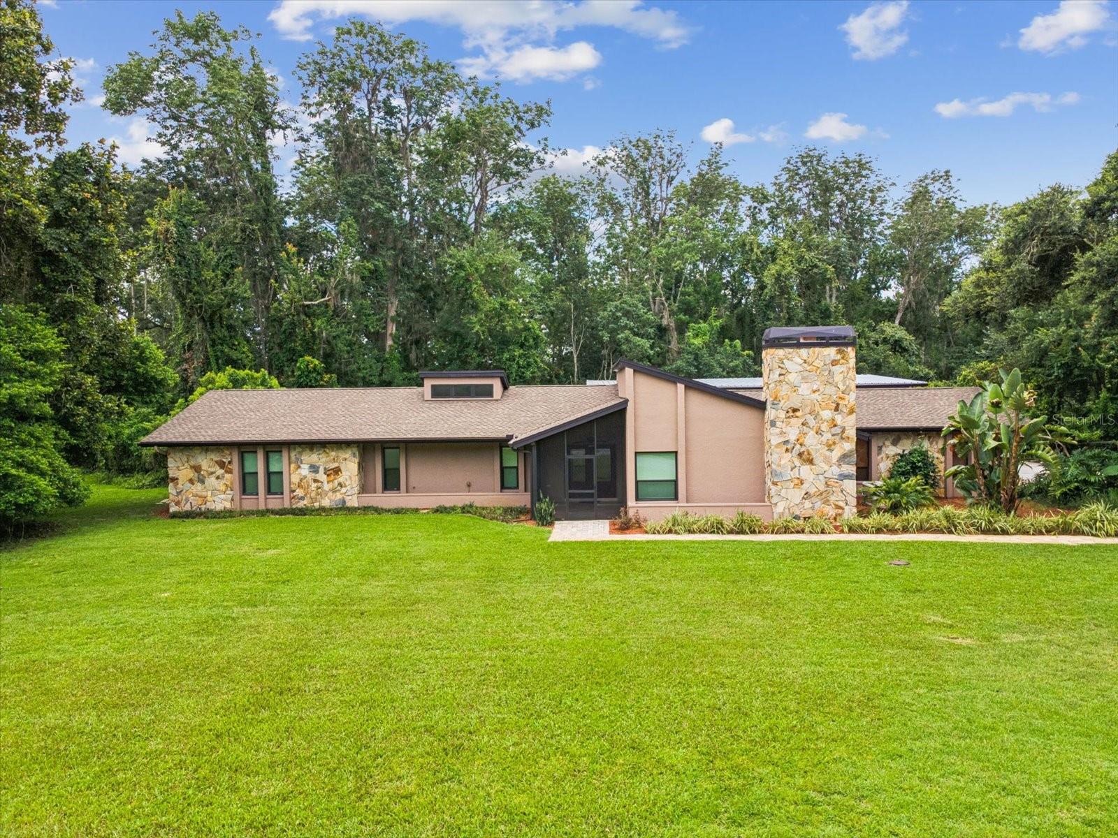 One or more photo(s) has been virtually staged. Rare opportunity to purchase secluded home in unique Hidden Lake Estates, a gated community. Double door entry invites you into a spacious foyer with a large atrium centered in the living space. Water and power supply in atrium offers a myriad of options to customize this space, perhaps a herb garden or pond with water feature? Walking around the atrium you take a step down to the living room with fireplace (propane) and recessed lighting. Continue around to the dining room which then takes you to the custom designed kitchen remodeled in 2018. Features include quartzite countertops, solid wood cabinetry with soft close drawer and doors and under cabinet lighting. Glass subway tile backsplash and a huge center island with even more storage and USB outlets. High-end stainless steel appliances, including a microwave drawer tucked away to the side of the double-oven range. Pendant lights illuminate the bar and matching chandelier over the island together with recessed lights provide plenty of light in the evenings. A perfect gathering spot, either seated around the island or at the bar shared with the family room. Family room has vaulted ceiling, clerestory windows, ceiling fan and stacking glass doors leading to large lanai. The lanai has plenty of space for entertaining (46’x12’), has 4 ceiling fans, terracotta tiled floor and can be accessed from kitchen, family room, primary suite and hangar. The living space is open, flexible and bright, porcelain tiled floors, except living room has laminate (2025). Guest bedroom off family room has mirrored closet doors, recessed lights and ceiling fan. Hallway from family room extends to guest bathroom with double vanity, then to third bedroom with ceiling fan and walk-in closet.
The primary suite is large with laminate flooring(2025), ceiling fan, walk-in closet in addition to closet space in bathroom. Bathroom has double vanity and space for a small make-up vanity. Exterior doors lead to lanai. There is a closet in the foyer and a laundry closet by the second bathroom. Spacious laundry room by the kitchen has huge pantry with roll-out drawers and built-in stainless steel utility sink. The laundry leads to a mud-room with storage and then to the attached two car garage with epoxy flooring. Water softener system replaced 2022.
The hangar is 49’ wide, 50’ deep with 3 sectional doors, the center pieces can be raised up when the doors are open. Access width 43' max, height 12' (approx) New Galvalume roof, insulation and gutters installed 2025. Epoxy flooring. Windows are double paned. All ceilings have remotes/ wall controls
All windows and door in the house are hurricane impact rated including the clerestory windows. Except the windows in the laundry room and garage have not been upgraded. The doors in the primary suite are double paned with mini-blind insets.
The whole house generator (22KW) is fueled by propane (250 gal tank - buried). ADT security system.
Hidden Lake Airport (FA40) has an asphalt runway 4,425' x 50', allowing many types of aircraft to use the facility. PAPI and full runway lighting allows night operations, so the runway is open 24/7. 100LL fuel available for purchase 24 hrs/day. The roads in Hidden Lake East also serve as active taxiways, allowing pilots to taxi their aircraft directly to the hangar at their home.