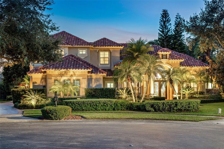 This newly renovated waterfront five-bedroom, 4.5-bath estate is the ultimate staycation residence, designed and built by a local resort developer who spared no expense in creating a luxury living experience. In one of Central Florida’s exclusive 24-hour guard-gated communities, the home offers an exceptional blend of luxury, privacy, security and recreation. Uniquely positioned on a quiet, pristine canal with direct access to the renowned Butler Chain of Lakes, this residence delivers an unparalleled waterfront lifestyle on one of the desirable lake systems in the state. The open-concept interior showcases expansive living spaces, soaring ceilings, and stunning water views throughout. A rare indoor half-court basketball and sports court features 25-foot vaulted ceilings, a regulation basketball hoop, stone fireplace, and a wall of glass French doors overlooking the pool, lanai and canal. This versatile space also serves as a spectacular entertaining area and could be reconfigured into a private guest or in-law suite with separate street access. The space includes a large-screen TV and high-definition projector for nighttime entertainment. Additional amenities include a first-floor 4K movie theater with 115-inch screen and surround sound, a 600-bottle temperature-controlled wine cellar with VintageView display, and a gourmet chef’s kitchen featuring all-new GE Monogram appliances, custom cabinetry, premium stone countertops, instant hot water and a silent remote blower hood system. A dual-use butler’s pantry and laundry room offers an extra dishwasher, sink, under-counter beverage and wine refrigerators, and generous counter space for small appliances. The primary suite is a private retreat featuring a spa-inspired bath with two-person soaking tub, fireplace, built-in TV, steam shower, instant gas water heater and automated blackout shades. Toto heated washlet systems are installed in all full baths. Outdoor living rivals a luxury resort with a 40-foot swimming pool and spa with gas and electric heat, custom pool finish, travertine decking, new screen enclosure and dramatic nighttime lighting. The covered lanai includes a summer kitchen, entertainment bar, gas fireplace, gas fire pit, 240-volt ceiling heater for year-round comfort, stone fountain wall and seamless connection to the indoor sports court. A private boat dock has been fully renovated with composite decking, new lift motor and cradle, automated boat cover, two covered jet ski lifts and paddleboard launch. Extensive upgrades include new impact windows, high-SEER HVAC systems, custom porcelain tile, custom cabinetry and stone counters throughout, custom iron front door, custom chandeliers, precast baseboards and crown molding, automated Control4 home automation with Alexa integration, landscape lighting throughout front yard, backyard and dock, new insulated garage doors with cameras, built-in garage cabinetry, maintenance-free garage flooring, 15KV generator, lightning protection system, concrete safe room with steel door, private monitoring security system and 16 exterior cameras. On a private cul-de-sac with no homes in front or behind, the property also offers access to community amenities, including tennis, pickleball, basketball courts, park, playground, fishing pond and 24/7 staffed gate.