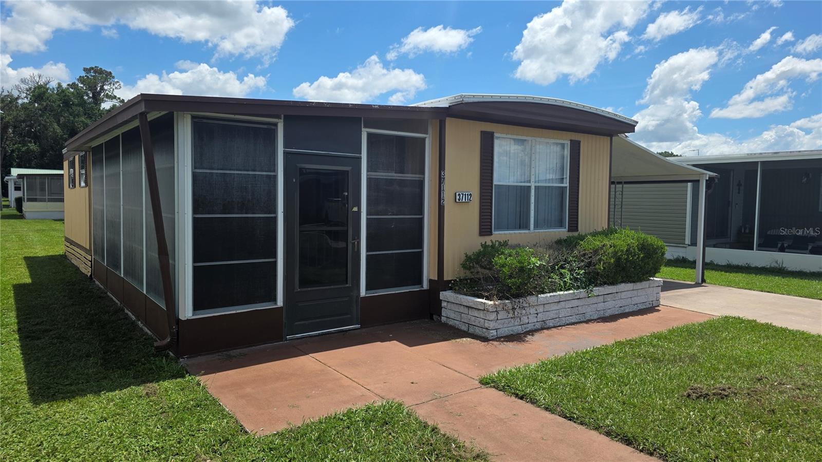 Furnished single-wide home with additions, offering two bedrooms and one and a half bathrooms. It features a new membrane roof, new sub-floor & drywall ceiling in the living room & new drywall ceiling & fan in the guest bedroom (5/2025) a spacious enclosed screen porch, front living room with built-in shelving, and numerous windows for plenty of natural light. The centrally located eat-in kitchen includes updated light fixture, a gas stove, vent hood, and a pantry. The expanded bedroom boasts two twin beds, a standard closet plus a linen closet, a ceiling fan, and an in-suite half bath with an updated vanity. The main bathroom, with an updated walk-in shower & vanity, is conveniently situated next to the second bedroom, located at the back of the home for extra privacy. Outside, the home has aluminum siding, a long driveway, and a carport with an attached utility room that houses storage space, shelving, and a washer and dryer. Additionally, there's a brick front planter and a sidewalk leading to the enclosed screen porch. All furnishings and major appliances will stay. Located in Betmar Acres. An active and friendly 55+ community where you own your land. No lot rent here and low annual park dues of only $465 yearly make this home a wonderful option for the active Florida lifestyle you desire. Betmar Acres offers lots to do to keep you busy whether it's playing Bingo or shuffleboard, going for a swim in the pools, relaxing in the parks 2 hot tubs, enjoying a round of golf, or playing pickleball this community has you covered. Come visit us today!
