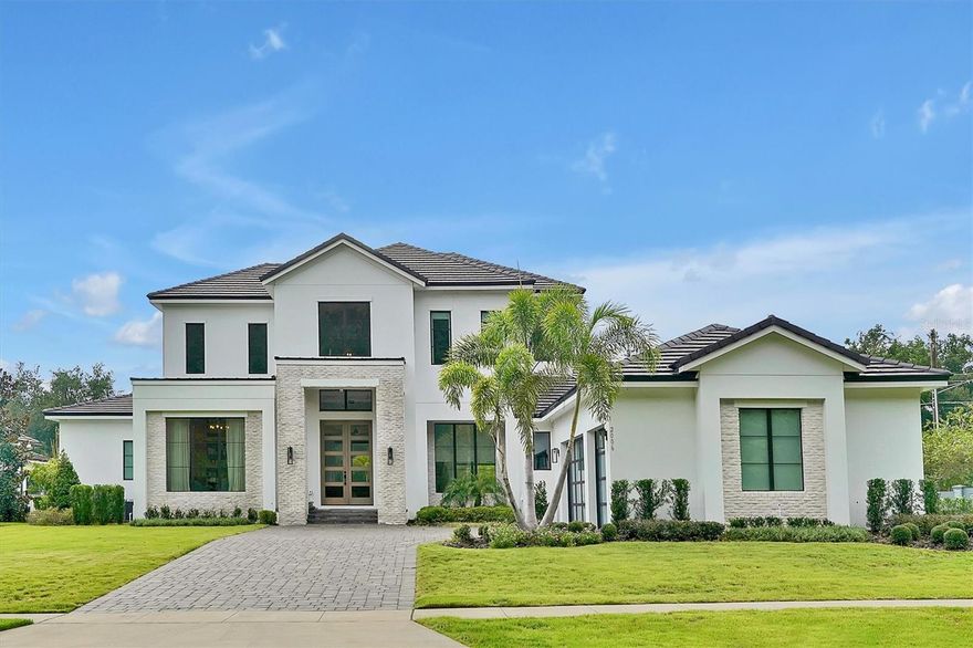 Welcome to the exquisite 2006 Bellamere Ct, a masterpiece crafted by Element Home Builders. Discover the epitome of luxury living with their renowned "Vineland" plan, showcasing unparalleled craftsmanship and meticulous attention to detail. This transitional gem offers a 5 bedroom, 4½ bathroom layout adorned with lofty ceilings, an array of pocket sliding glass doors, and thoughtfully designed living spaces that seamlessly flow. 
The residence offers 2 flex spaces turned to offices with wonderful built ins with lighting that gives it an extra sophisticated atmosphere. The first floor master bedroom features a huge bathroom with a walk-in closet with built ins and a central island for your jewelry and extra room.
Indulge in culinary delights within the open kitchen, adorned with a grand waterfall countertop island, a sophisticated dining area, and an inviting great room. A bespoke office space with built-ins and a refined entertainment haven await, featuring a game room complemented by a snack bar and a discreet mini-fridge.
Every step graced by engineered hardwood floors, and every glance met with elegance through vinyl double pane windows and decorative glass entry doors. Modern luxuries abound, from tank-less hot water heaters to spray foam insulation. The paver driveway and insulated 3 car garage doors culminate in an epoxy-finished garage floor, all seamlessly integrated.
AC zones cater to your comfort, while detailed ceilings, quartz countertops, a walk-in pantry, and generous built-in closets define sophistication. Top-tier Thermador appliances and custom shelving enhance functionality, while seamless glass shower enclosures and designer LED lighting add finesse. 
Step into the outdoor oasis, where a captivating pool and spa await. The summer kitchen, graced with Marine grade cabinetry, sink, and grill, beckons for alfresco gatherings on the travertine pool deck. A vast covered living space ensures year-round enjoyment.
Set upon a sprawling oversized .65-acre parcel, this home boasts a premium landscape package and lush zoysia grass. Nestled within an exclusive community of just 12 estates, each site over half an acre, this residence is a testament to Windermere's untouched splendor. Majestic pine and oak trees frame this locale, with elevations offering panoramic views across eleven interconnecting lakes.
Windermere, a haven of natural beauty, is adorned with crystal-clear lakes and pristine panoramas. Nestled amidst this serenity, you remain well-connected to A-rated schools, verdant parks, a vibrant farmer's market, renowned golf courses, delectable dining, and world-class attractions including Disney World and Universal Studios. The house has a paid off solar panel.