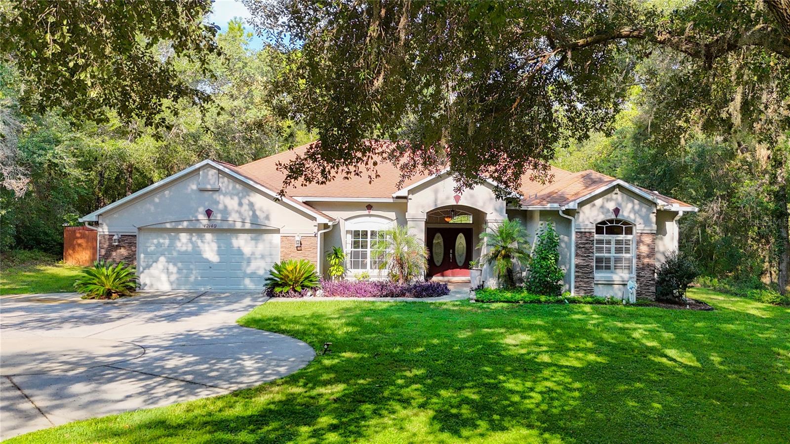 Elegant, custom built 3-bedroom estate pool home situated on 1 acre with a BRAND-NEW ROOF TO BE INSTALLED PRIOR TO CLOSING. Welcome to this exceptional 3-bedroom, 2-bath residence, nestled on a picturesque 1-acre lot adorned with graceful, wooded views and a distinctive stone-accented exterior and a fenced yard. The property welcomes you with a double door entry and features both an extended driveway and turnaround drive—offering abundant space for guests and family. Step inside to discover an elegant formal living room, graced by tray ceilings, and a dedicated formal dining room—perfect for hosting sophisticated gatherings. The home’s heart is its spacious kitchen/family room combination, where the family room boasts a stunning stone-faced gas fireplace and sliding doors that open to a screened, diamond brite pool. The pool dazzles with pop-up cleaning jets, a newer motor and light, and is framed by a tranquil lanai and an attached shed for convenient storage. The kitchen is a chef’s dream, featuring quartz countertops, an extended breakfast bar, a closet pantry, generous cabinet and counter space, newer stainless-steel appliances that add a touch of modern luxury, and an eat-in area with frameless windows overlooking the sparkling pool. The master suite is a private sanctuary—expansive in size with French doors leading directly to the lanai, double walk-in closets, and an elegant master bath. Indulge in the jacuzzi tub, custom tile shower, and double sinks, designed for ultimate relaxation. Both additional bedrooms are generously sized—the second bedroom features double closets, and the third is also large and versatile. The second bath conveniently serves as a pool bath, ensuring easy access for guests and family alike. Additional features include: AC 2016, newer water heater, an office nook with integrated built-in desk and cabinetry, an oversized two-car garage with utility vacuum and generator hookup, Inside laundry room with washer, dryer, utility sink, counter space, and cabinets, rear two-car carport for extra covered parking, and a rainbird sprinkler system. This beautiful home seamlessly blends luxury, comfort, and functionality, creating a haven both indoors and out. Whether entertaining in the formal areas, relaxing by the pool, or enjoying the peace of the wooded acreage, this property offers an unparalleled lifestyle for any buyer. Outdoor enthusiasts will appreciate being just 20 minutes from the public boat ramp to Henderson Lake and the Tsala Apopka Chain of Lakes—perfect for boating, fishing, and wildlife watching. Don’t miss this opportunity to own a peaceful retreat that’s close to everything! CONVENIENTLY & CENTRALLY located just 12mi from both Inverness & Brooksville. NO HOA.
