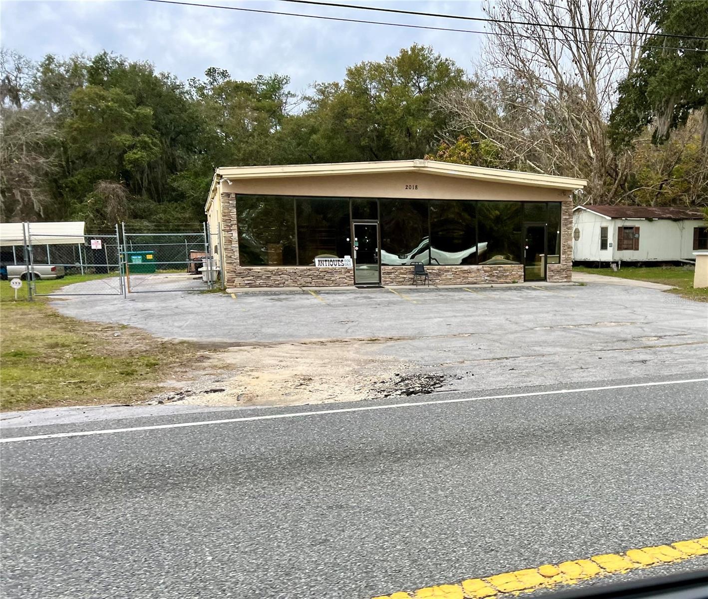 This is a rare opportunity to own two commercial properties in a high-traffic area for the price of one. The main building is currently occupied by two businesses, a retail antique store and a sign fabrication/car restoration business. The versatile building has six offices/rooms, built-in desks and cabinets, a kitchen area, two bathrooms, and two sales areas. There is also a warehouse/garage area with three bay doors and an office. The lot next door is also included in this sale and is zoned GNC. This lot could be used for additional parking, storage, or for another business. The property has 200 feet of frontage on Highway 41, which provides excellent visibility and accessibility. This is a great opportunity for an investor or business owner.