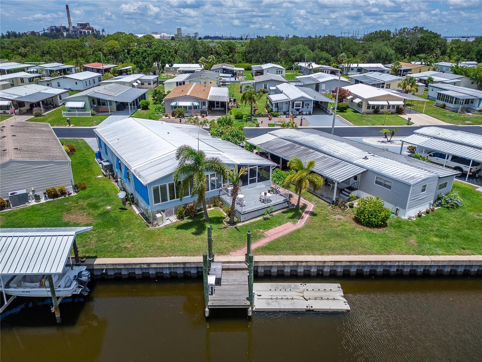 WATERFRONT BEAUTY WITH DOCK & TONS OF UPGRADES!** This move-in-ready 2 bedroom, 2 bath manufactured home in the 55+ Caribbean Isles Residential Cooperative offers exceptional value and peace of mind—NO LOT RENT, as ownership includes a share in the community. Best of all, this home has never flooded and flood insurance is transferrable to the new owner. Enjoy direct canal access to Tampa Bay and the Gulf of Mexico from your private dock, perfect for boaters or anyone who loves waterfront living. A new metal roof-over, new waterproof vinyl plank flooring, and new subfloors provide long-term durability. The HVAC was replaced in 2020, and a mini-split AC was added to the Florida Room in 2022, making this space comfortable year-round. The kitchen features upgraded, matching, stainless appliances, including a 2025 French door refrigerator and garbage disposal. A whole-house reverse osmosis water treatment system (installed in 2023), eco-friendly toilets (2022), and updated light fixtures (2022–2025) reflect the care and quality invested throughout. The primary bedroom includes a remote-controlled ceiling fan (2025) for added comfort. Exterior upgrades include vinyl siding, storm shutters (2023), leaf guard gutter protection, and beautiful hardscaping. With two driveways and parking for up to four vehicles, you’ll have plenty of room for guests. Caribbean Isles offers a resort-style lifestyle with a heated pool, clubhouse, boat launch, library, game and craft rooms, and year-round social activities and events. Located in Apollo Beach, you're perfectly positioned between Tampa and Sarasota for endless shopping, dining, and recreation. Don't miss your chance to own this upgraded, waterfront home in one of Apollo Beach’s most sought-after 55+ communities!