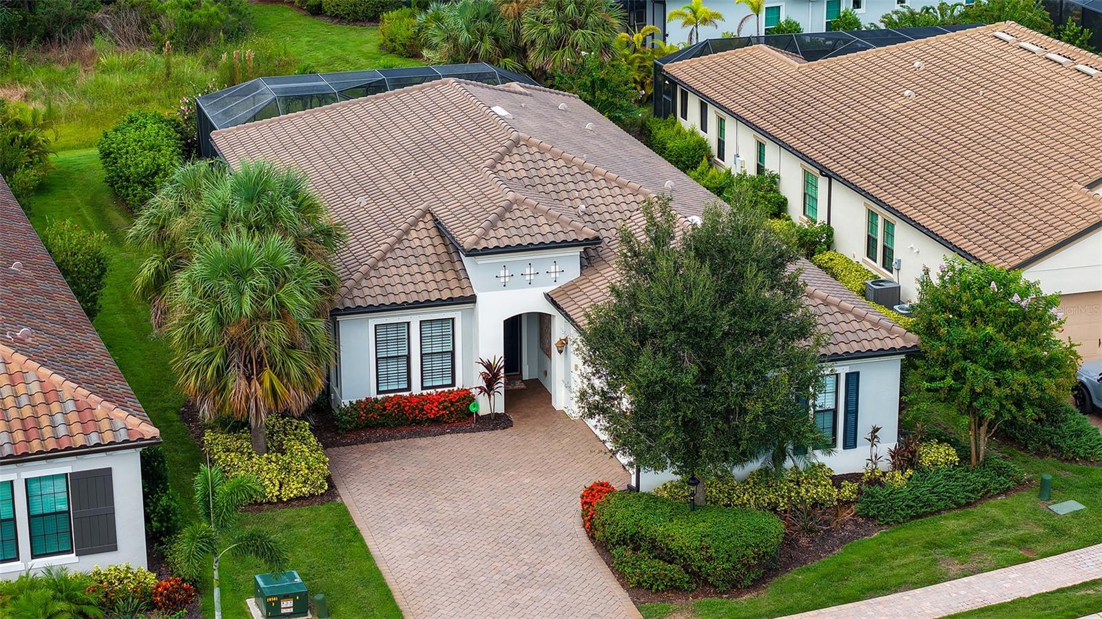 Welcome Home to luxury living in the sought after community of Country Club East, in Lakewood Ranch! This FORMER MODEL home, WCI's San Remo, delivers a plethora of design extras and upgrades that bring a modern, yet cozy feel to the OPEN FLOOR PLAN. Upon entering this 3 bedroom, 2 1/2 bath WITH STUDY home, you will notice the upgraded 8 foot doors throughout the home, upgraded 5 1/4" crown molding throughout, recessed can lighting throughout main living areas, high ceilings throughout, light and soft cream shiplap on the walls in the study, the tongue and groove stained woodwork in the ceiling trays, the board and batten woodwork along the walls, soft Kingston Oak plank style engineered hardwood floors, and a collection of warm hues that bring harmony to this professionally designed home. Among the numerous upgrades, this home features luxury gas kitchen package with Kitchen Aid stainless steel appliances, granite dream leather countertops with flat polished edge, solid wood 42 inch upper cabinets, upgraded faucet with single bowl sink, and closet built ins included in the primary bedroom closet. Mature landscaping in the exterior of the home offers privacy and serene outdoor living. Lanai features include roman style pool and spa, as well as large covered space with outdoor kitchen featuring oversized barbecue grill with hood and refrigerator and sink. Covered area includes a closing sunshade which features privacy on the exterior, yet transparency from the interior. Country Club East residents have exclusive access to the TWO neighborhood amenity centers, The Retreat, which includes a fitness center, a resort style pool as well as a gathering space with a billiards room, and The Residents Club, which offers an additional pool as well as a volleyball court. Various memberships to Lakewood Ranch Golf & Country Club may be available, but are not mandatory. The Lakewood Ranch Golf and Country Club offers 72 holes of golf, 20 Har-Tru tennis courts, 20 pickleball courts, clubhouse, and The Lodge, which houses a bar and restaurant. Country Club East is a gated, mature neighborhood in the heart of Lakewood Ranch with sprawling green spaces and easy access to Waterside shops and restaurants, Lakewood Ranch Main Street, UTC Mall, world class beaches, and the SRQ Airport. Book your appointment today!