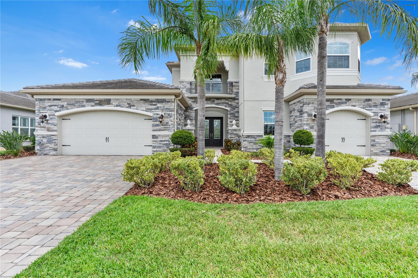 Welcome to 2321 Hollow Forest Court – a true showpiece nestled in the highly sought-after Ridge at Wiregrass community in Wesley Chapel. This stunning Sebastian model by GL Homes offers a thoughtfully designed floor plan, sitting on nearly one-third of an acre with breathtaking conservation views.
With nearly 4,500 square feet of luxurious living space, this better-than-new home is loaded with high-end designer upgrades and elegant finishes throughout. It features 5 spacious bedrooms (including one converted into a custom home theater),a home office/den, 5.5 bathrooms, and a 3-car split garage.
Tucked near a cul-de-sac, the home makes a striking first impression w/ its tile roof, paver driveway, and eye-catching brick upgraded elevation. Double entry glass doors welcome you into a grand two-story foyer highlighted by a winding staircase & beautiful porcelain tile floors, setting the tone for the sophisticated interiors that follow.
Step into the expansive great room with soaring 22-foot ceilings, flooded w/ natural light from oversized sliding glass doors & windows that frame stunning views of the lush conservation area. The backyard is a blank canvas, an oversized, private outdoor retreat ready for you to transform into your dream oasis.
Back inside, the chef’s kitchen is the heart of the home, blending elegance and function. It features custom contemporary shaker-style cabinetry that extends to the ceiling, quartz countertops, an island, & premium appliances including a Bosch refrigerator, double ovens, gas cooktop, pot filler, and stainless steel vent hood. The space flows effortlessly into the eat-in peninsula, formal dining room w/ a convenient pass-through, & a wet bar, perfect for entertaining.
On the first floor, the spacious primary suite offers a tranquil escape w/ large windows, a coffered ceiling+ dual oversized walk-in closets. The en-suite bath is designed for relaxation, w/ double quartz vanities, a walk-in shower, & spa-like finishes. On the opposite wing, you’ll find a private guest suite w/ full bath+ a mudroom, laundry room, powder bath, and a stylish home office w/ wood flooring.
Upstairs, discover three additional bedrooms, one w/ its own en-suite bath & walk-in closet, one being used as a custom-built home theater, perfect for family movie nights or game day gatherings.
The 3-car garage includes an air-conditioned storage room, ideal for keeping valuables protected year-round. This home is loaded w/ over $250,000 in upgrades, including, premium kitchen and bath packages, surround sound/AV systems, designer Restoration Hardware lighting, upgraded wood staircase and flooring, gutters, professional landscaping, top of line brick elevation + extended driveways, water softener, window treatments, and more! The resort-style clubhouse offers luxurious amenities, including a beach entry pool, waterslide, fire pit, lap pool, tennis courts, outdoor sports court, beach volleyball, playground, playfield, and party pavilion. Enjoy a social hall, sports complex, game room, fitness center, and more. The community offers a full-time gate guard and maintenance-free living, with the HOA fee covering lawn mowing, some landscape maintenance, fertilization & yearly mulch. Conveniently located near top-rated Wiregrass schools, I-75, Wiregrass Mall, The Grove, Wiregrass Sports Campus, Tampa Premium Outlets, hospitals, restaurants, and more, this home provides a luxurious and convenient lifestyle for its residents.