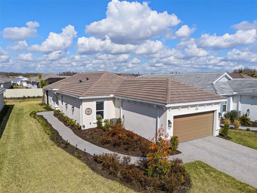 What if the best part of living in Esplanade wasn’t just the home itself, but being only steps from everything that makes the community come alive? This 2-bedroom plus private study Roma residence sits directly across from the clubhouse, placing connection, activity, and convenience right outside your front door.

With 1,689 heated square feet, the layout feels balanced, comfortable, and easy to live in. A side entry welcomes you into a bright, open living space where the kitchen anchors the home with soft gray cabinetry, quartz countertops, stainless steel appliances, recessed lighting, and wide-plank tile flooring throughout. The flow feels natural and calm, creating a setting that works just as well for quiet mornings as it does for relaxed evenings with friends.

A split-bedroom design offers privacy for guests, while the private study provides flexibility for a home office, reading room, or hobby space. The primary suite is filled with natural light from a bay window and features dual vanities, an oversized walk-in shower, and a generous walk-in closet.

The screened lanai and extended patio create a seamless indoor-outdoor transition, perfect for morning coffee or a peaceful evening outdoors. Lawn maintenance is included through the association, allowing you to enjoy a low-maintenance lifestyle. An extended 4-foot garage adds practical storage and everyday functionality.

One of the biggest advantages of this home is its location within the community. While newer construction opportunities are positioned toward the back of Esplanade, approximately a mile from the clubhouse, this residence offers immediate access to the heart of the neighborhood. If you plan to fully enjoy the events, activities, and amenities, being only steps away creates a completely different daily experience. You feel connected to the community, without the distraction of ongoing construction.

Esplanade at Wiregrass Ranch is a gated 55+ lifestyle community known for its resort-style atmosphere and active social calendar. Residents enjoy a full-service spa, on-site restaurant and café, Har-Tru tennis courts, pickleball courts, shuffleboard, a hot tub, resort-style walk-in pool, walking trails, clubhouse with concierge services, and two dog parks.

Publix and Walmart are less than a mile away, with Wiregrass Shops, Tampa Premium Outlets, and nearby medical facilities just minutes from home. The property is located in Flood Zone X for added peace of mind.

Comfortable. Connected. Low maintenance.

You are not just buying a beautiful home. You are stepping into a lifestyle designed around ease, activity, and community.