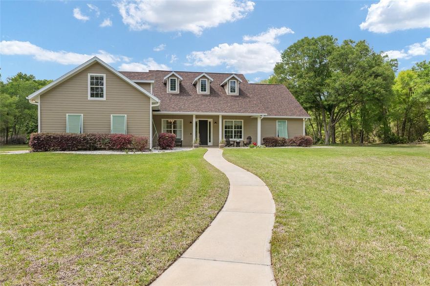 As you pull through the gates, you immediately feel the difference. There’s space here. Not just in the size of the lot, but in the way the property lives. It feels open, yet private, and just far enough removed without giving up convenience. The winding drive leads through a canopy of trees to this beautifully positioned home on 5.33 acres in the gated, horse-friendly community of The Trails. This 4BR, 3BA home with bonus room offers a strong combination of functionality, flexibility, and privacy. Inside, you’ll find an open layout with 12' ceilings, 10' doors, and natural light throughout the main living areas. The living room features custom built-ins and French doors leading to the screened lanai and pool. The kitchen is open to the main space and connected to both the breakfast nook and dining area, with stainless appliances, abundant cabinetry, generous counter space, center island, walk-in pantry, bar seating, and a gas line stubbed behind the range. The breakfast nook overlooks the pool, and the dining room near the entry offers flexibility depending on how you live. The 4th bedroom is currently used as an office just off the main living area. The split bedroom plan provides privacy, with a spacious primary suite featuring multiple windows, a window seat with storage, dual vanities, soaking tub, large walk-in shower with dual heads, and two walk-in closets. Two guest bedrooms share a Jack and Jill bath with private vanity areas, and a separate pool bath offers direct lanai access. Just off the garage entry is a drop zone with built-ins, along with a laundry room offering counter space, cabinetry, and a utility sink, plus additional storage under the stairs. Upstairs, the bonus room over the garage provides a large, flexible space for a variety of uses. The attached 3-car garage includes high ceilings, dual doors, and a hidden lockable storage or safe room. The screened lanai with paver flooring creates a true outdoor living space with room for both lounging and dining, and a gas line is already in place for a future outdoor kitchen. The saltwater pool features a raised water element, expansive paver deck, and pool fence. A detached 2-car garage offers additional workspace and storage with attic access above, along with an attached carport. A separate 24'x24' covered carport provides even more space for vehicles, trailers, or equipment. The property itself offers a mix of cleared yard and mature trees, with a gate providing direct access to the community horse trail. Additional features include central vacuum, generator wiring, a 250# propane tank, 2020 Trane HVAC, 2023 roof, and 2023 well bladder tank, all serviced by Clay Electric. Located just minutes to Publix and everyday conveniences with an easy drive into Gainesville, UF, and Shands, this property offers space, flexibility, and a setting that’s hard to replicate.