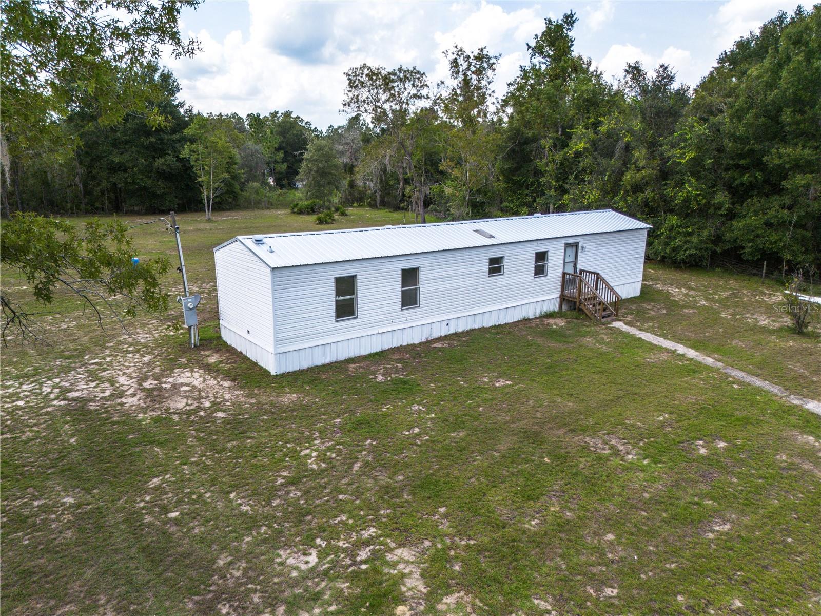 Welcome to this 2 bedroom 2 bathroom fully remodeled home situated on 1.35 acres. The living room, kitchen, and bedrooms feature beautiful vinyl wood flooring throughout. The spacious kitchen offers ample pantry space and a dining area. This home has a split floor plan, providing an open layout which is a great use of space and great for entertaining and relaxing. Numerous updates have been made in the last few years, with one of the most significant additions being a new metal roof that has been installed on the house. Updates include new flooring, fresh interior paint, and stainless steel appliances. The large oversized yard allows for additional outbuildings and plenty of room for recreational activities. Fully fenced in yard with fresh spring water that comes straight from the ground and you will never have a water bill! Water is plumbed throughout the yard which is perfect for animals and a garden. The home is conveniently located near Gainesville but with Levy County taxes! No HOA and is on Central Florida Electric which is very affordable. Great first home and move-in ready. Schedule an appointment to view it today!