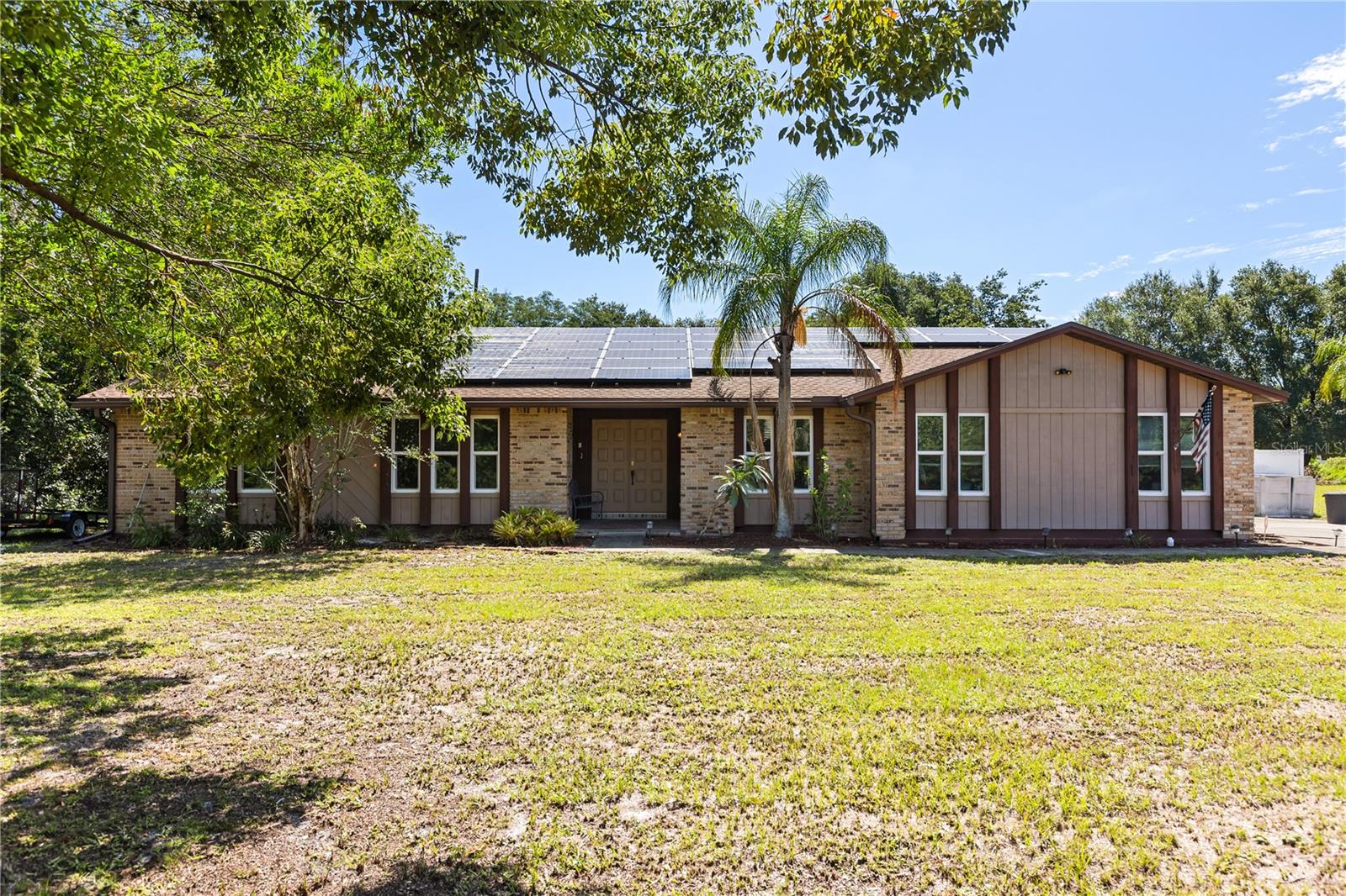 All-brick beauty with wood trim located in the sought-after Deltona Estate area, set on almost an acre of fully fenced property. This spacious home offers a split-bedroom layout, a wood-burning fireplace in the family room, and an in-ground screened pool with a large, shaded lanai—perfect for enjoying warm Florida days or hosting gatherings. Inside, you’ll find all-new flooring, a remodeled kitchen with light cabinetry, granite countertops, and modern finishes, along with fresh interior paint and smooth ceilings after the removal of the popcorn texture. Recent updates provide peace of mind, including a 2023 roof, windows replaced less than five years ago, and a hot water heater installed in 2018. The home also features solar panels for energy efficiency, a 2-car garage, and a whole-home water filtration system. The washer and dryer stay with the property. VA Buyers will also appreciate the option to purchase with an assumable loan at a 6.125% interest rate. With almost an acre of fenced space and a poolside retreat, this property offers both privacy and room to enjoy the Florida lifestyle. NO HOA so bring all your toys!