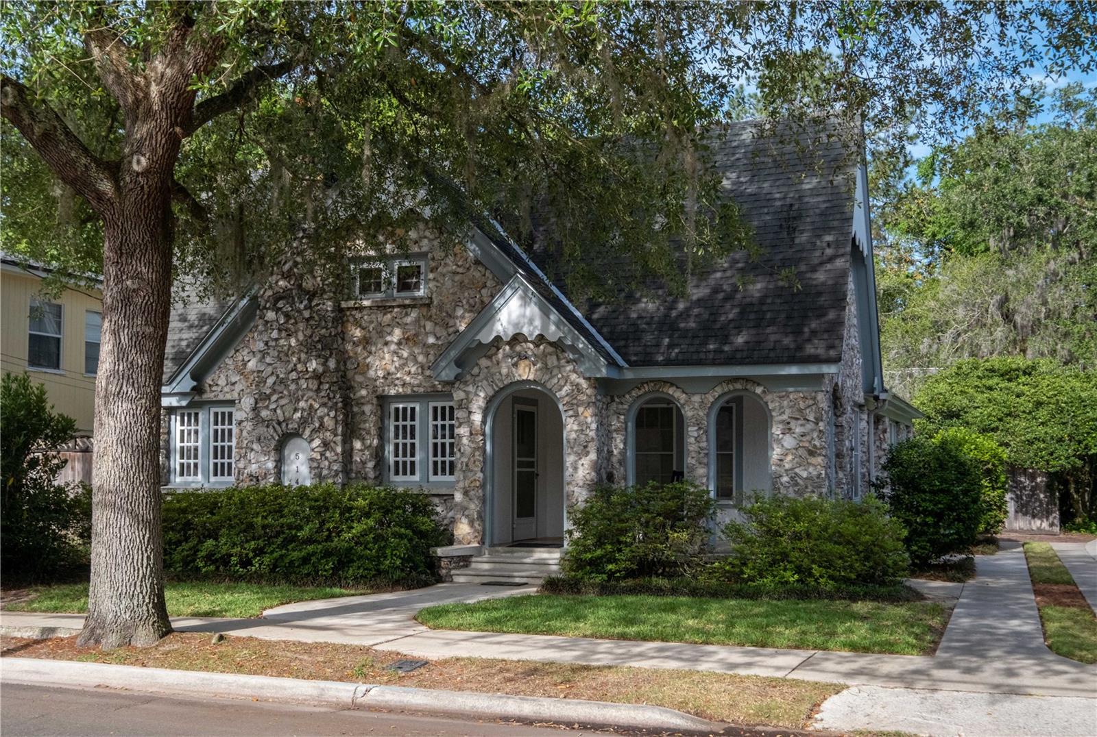 Special and rare chert bungalow on one of the loveliest streets in the Duckpond neighborhood includes a custom designed detached accessory dwelling. This storybook cottage has a classic layout with a proper living room, dining room and the potential for three bedrooms. The living room includes a gas fireplace with hand-selected black slate. The spacious dining room connects to a cozy breakfast nook with the original built-in corner cabinets. Currently, the owners’ suite includes two of the original bedrooms and features a private entrance from the driveway along with custom bookshelves. These rooms could be easily divided, if a third bedroom or office is desired. Gorgeous hardwood floors, woodwork and windows throughout. The laundry room is located just off the kitchen with a door to the meticulously maintained landscaped property that includes a wooden deck and pergola. The detached studio is set far back onto the spacious lot that includes a tiered fountain, storage space, privacy fencing and mature plantings. The detached studio has an open living plan on the main floor with a unique brick floor and a fully-functional kitchen with a breakfast bar and plenty of cabinetry. The lofted bedroom is accessed from a fantastic spiral staircase. The bathroom features a unique clawfoot tub and vanity. Plumbing supply lines and water heaters updated in 2022. Exterior painted in 2021 and the chert is maintenance free. Truly magical.