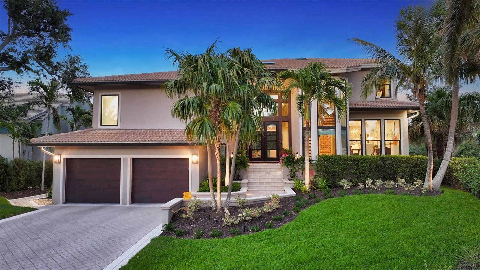 Under contract-accepting backup offers. Welcome to the exclusive, double-gated Bay Isles Bayou community on Longboat Key, where privacy meets refined coastal living. This stunning waterfront residence sitting on 0.28 acres has undergone a complete, top-to-bottom renovation and now showcases 115 feet of serene waterfront frontage—a tranquil setting frequented by swans, otters, and a variety of native birds. From the moment you arrive, the architectural impact of the custom 20-foot front entry and the oversized impact glass windows and doors—featured throughout the entire home—sets the tone for the level of craftsmanship within. Designed for both beauty and resilience, these premium installations provide the ultimate in storm protection and long-term peace of mind. Inside, the kitchen is a true showpiece, thoughtfully designed with a full tile wall backsplash, Campbell solid wood cabinetry with panel-front appliances, a striking quartzite waterfall island with a custom oversized sink and dual faucets, and an elite suite of appliances including a Sub-Zero refrigerator and freezer, Sub-Zero drawer beverage coolers, Wolf gas range, Miele wall oven, in-wall coffee system, steam oven, and Cove dishwasher. Wide-plank, high-end engineered hardwood flooring flows seamlessly throughout the home. The custom staircase with glass panel railings adds a sleek modern touch and enhances the open feel of the interior. The owner’s suite is a sanctuary overlooking the water, and its spa-like bath is straight from the pages of *Architectural Digest*, featuring Campbell custom cabinetry, walls of designer mirrors, and exquisite statement lighting. A brand-new resort-style heated and saltwater pool with a picture-frame screen enclosure offers uninterrupted views of the water and the lush, professionally landscaped surroundings. The oversized two-car garage includes an air-conditioned storage room for added convenience. This is more than a renovation—it’s a reimagining of luxury coastal living, finished with the highest attention to detail and quality. As a resident of Bay Isles, you’ll enjoy deeded access to the private Bay Isles Beach Club, as well as proximity to the Longboat Key Club’s renowned golf, tennis, spa, dining, and marina amenities. Just moments from Publix, the tennis center, town library, and local art shows, and a short drive to St. Armands Circle, Downtown Sarasota, and SRQ Airport—this home delivers the very best of Longboat Key living.