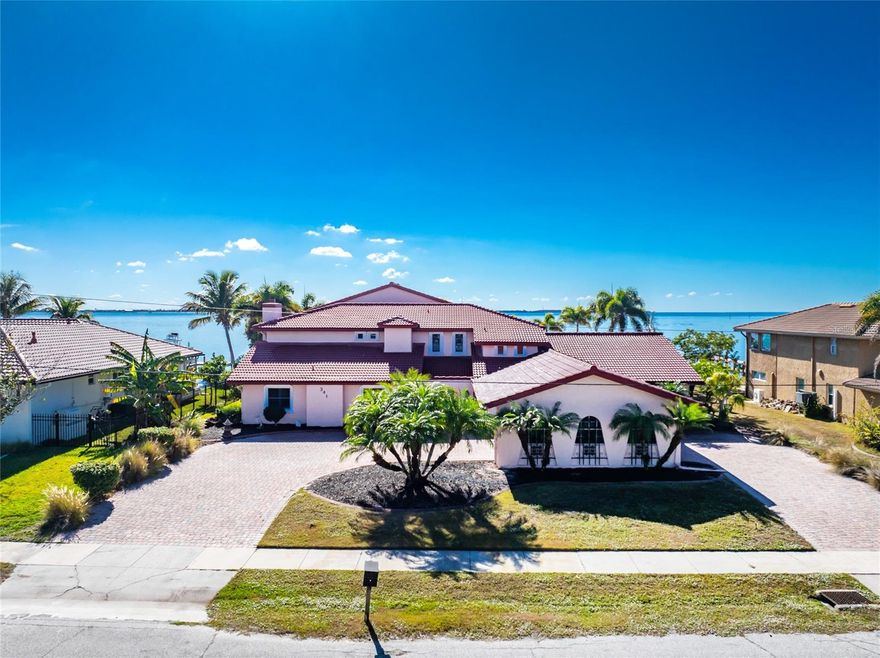 Unmatched harbor views, endless potential, and a true boater’s paradise. This exceptional waterfront estate offers breathtaking, million-dollar panoramic views of Charlotte Harbor and an incredible opportunity to create a custom luxury retreat. Featuring 5 bedrooms, 4.5 bathrooms, and approximately 6,100 sq ft of living space, this home is positioned to capture stunning water views from nearly every angle. Recent upgrades include brand-new flooring and bathroom vanities (2025), a brand-new dock, and a fully restored retaining wall, giving peace of mind and immediate value. The lower level has been completely gutted following storm damage from Hurricanes Milton and Helene, with drywall removed and flooring stripped—providing a blank canvas ready for your vision and design. The main level offers four spacious bedrooms, while the second floor is dedicated to the private primary suite and an expansive bonus room wrapped in windows, showcasing unforgettable harbor views. An elevator provides convenient access between levels, and the unique dual drive-through driveway and garage allows access from either side of the property. Additional features include a tile roof (2018), newer A/C systems (2019), hurricane-impact windows and sliders throughout, public water and sewer, and no bridge access, making this an ideal property for any size vessel. Perfectly located just minutes to restaurants, shopping, and downtown Punta Gorda, and under 30 minutes to Englewood Beach and Boca Grande, this home is priced below market value, leaving substantial room for renovation, customization, and future equity. Rare views. Prime location. Unlimited potential. Don’t miss this opportunity to transform a remarkable waterfront property into a true Charlotte Harbor showpiece.