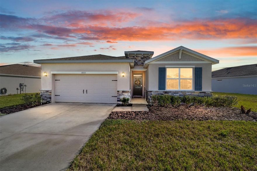 This beautifully maintained Delray Model built in 2024 offers 4 bedrooms, 2 bathrooms, and a 2-car garage with 2,034 sq ft of living space. The home features an attractive stone-accented front elevation and a welcoming tile entry leading into an open and functional floor plan. The kitchen is designed for both everyday living and entertaining with granite countertops, a large island, white staggered cabinetry with crown molding, under-cabinet lighting, pendant lighting, a walk-in pantry, and stainless Whirlpool appliances. Tile flooring runs throughout the main living areas, while the bedrooms feature comfortable carpet and window blinds. The spacious primary suite includes two walk-in closets and a private ensuite bath with a double granite vanity and a tiled shower with glass enclosure. Sliding glass doors lead to a screened lanai, perfect for relaxing or entertaining outdoors. The rear property line includes vinyl fencing with the option for a buyer to add chain link fencing to fully enclose the yard. Additional features include a smart home system that is Alexa-ready, Whirlpool washer and dryer, and pendant lighting in the dining area. The A/C system includes a UV light designed to help reduce mold, bacteria, and other airborne contaminants within the system, which can improve indoor air quality and help keep the HVAC system cleaner. The home currently has termite protection in place, providing added peace of mind for the homeowner. Located in the desirable JB Ranch community with convenient access to shopping, dining, and everyday amenities! Call for your private showing today!