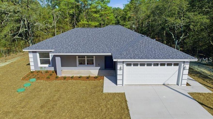 Under Construction. Welcome to your quiet escape! This BRAND NEW HOME is currently under construction. This 3 bedroom, 2 bath, offers modern comfort and thoughtful design and a 2-car garage. Enjoy beautiful curb appeal with fresh landscaping and a spacious covered front porch, perfect for relaxing mornings or evenings. Step inside to an open-concept floor plan featuring a split-bedroom layout, vaulted ceilings, ceiling fans, and luxury vinyl plank flooring throughout the main living areas. The bright kitchen is a true centerpiece, complete with an island, granite countertops, slow-close cabinetry, and a brand-new stainless steel appliances. The primary suite boasts a tray ceiling, a generous walk-in closet, and a private en-suite bathroom with dual vanities and a walk-in shower. Bedrooms two and three are located on the opposite side of the home, with a conveniently placed guest bathroom featuring a tub and tile surround. The indoor laundry room is conveniently located just inside the home off the garage entry. Enjoy outdoor living on the 15x10 covered back porch, complemented by a 10x12 extended concrete patio—perfect for grilling, entertaining, or simply unwinding at the end of the day. Conveniently located in Ocklawaha, this home offers the perfect balance of peace and accessibility, just 10 minutes from The Villages and approximately 25 minutes to downtown Ocala. Don’t miss the opportunity to own this beautiful new construction home—schedule your showing today!  Current pictures are from the same model but in different location, color scheme may vary.