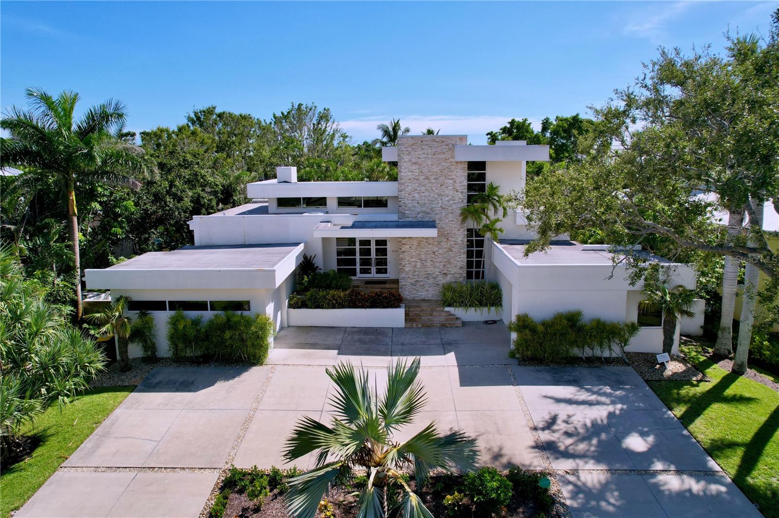 Discover unparalleled luxury in this stunning home located in the one of the most prized addresses in Sarasota HARBOR ACRES neighborhood. This exceptional residence features 5 spacious bedrooms, perfect for family and guests, and a versatile home office for those who work remotely.
As you approach, admire the elegant circular driveway and beautifully landscaped front yard. The entrance boasts a dramatic stone feature wall and double doors, welcoming you to your next chapter of elegance and comfort.
The expansive great room is filled with natural light and seamlessly connects to an outdoor living space, creating an ideal setting for gatherings. A stylish gas fireplace flanked by modern floating shelves enhances the cozy ambiance.
The gourmet kitchen is a chef’s dream, featuring high-end Miele appliances, custom solid wood cabinetry, quartz countertops, and a spacious island perfect for entertaining. The convenient butler’s pantry adds extra functionality for effortless hosting.
Retreat to the luxurious first-floor master suite, complete with two generous walk-in closets and a spa-like bathroom offering serene tropical views—a perfect escape after a long day.
Each of the five bedrooms is thoughtfully designed, ensuring comfort and privacy, with two additional en-suite bedrooms located upstairs for family or guests.
Additionally, the property features a unique converted garage that has been transformed into a fully-equipped home gym, providing a perfect space for workouts without leaving the comfort of your home.
Step outside to the stunning lanai, featuring an outdoor kitchen, a heated salt-water pool with an infinity edge, and a cozy firepit surrounded by lush landscaping for ultimate privacy.
Excellent Schools, Close to Morton's Market, Local Restaurants, Shopping, Sarasota Memorial Hospital, Downtown Sarasota, St Armand's plus Easy Access to the Best Florida Beaches!
Make this luxurious residence your new rental home in the sought-after Harbor Acres community today!