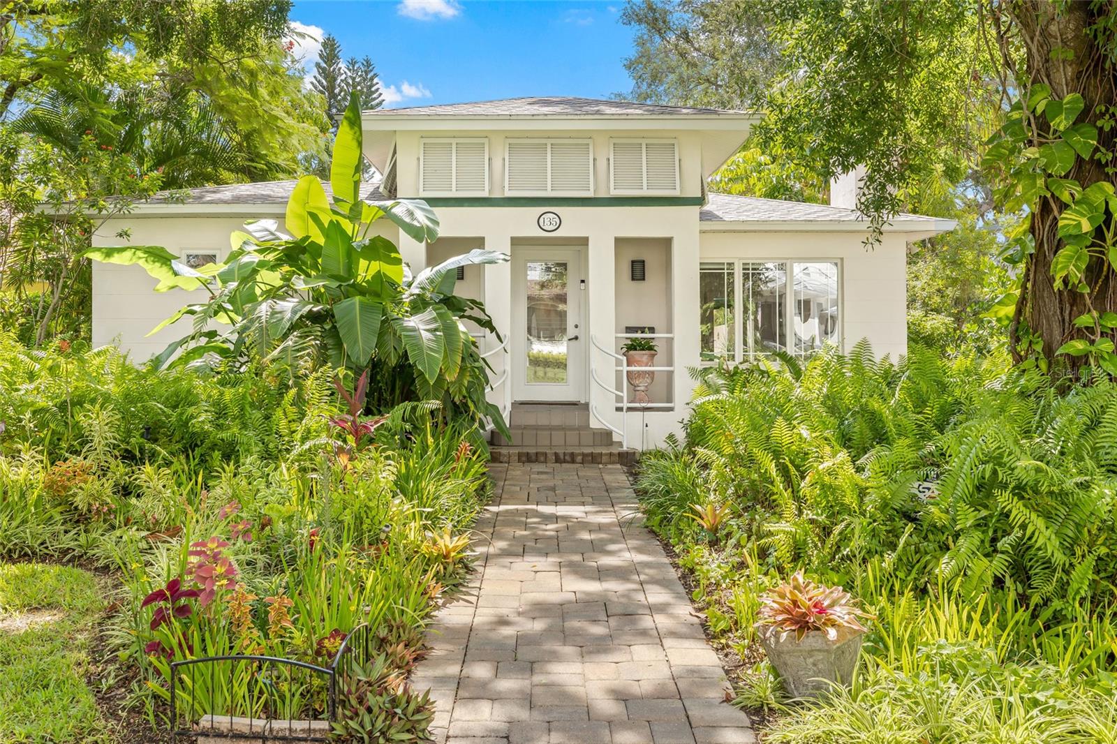 A must-see mid-century modern beauty with European flair located in coveted Snell Isle, St. Petersburg, FL. No damage or flooding occurred at this residence during Hurricane Helene or Milton. Elevated with inflections of Art Nouveau design, this open-concept main home features gleaming Oak hardwood floors, a stately front approach with foyer, decorative fireplace anchoring the large living space, modern kitchen providing scenic views to the courtyard pool and two bedrooms, each with their own en-suite bathroom. For those that host frequent guests, house a multi-generational family member, or simply want to benefit from rental income while still honoring privacy, the rear casita provides just that. Complete with an additional bedroom and en-suite full bath, mini-split for cooling and adjacent laundry room, guests or residents will adore their separate quarters. Between the home and casita lies a tranquil pool and hot tub surrounded by lush landscaping and a courtyard with decorative artisan tiles adding a touch of whimsy to this tropical space. Located among multi-million dollar estates, this single-level home is a hidden gem. Elevated on a crawl space, the home has been lovingly cared for by the same owners for 40 years. A labor of love has gone into the gorgeous landscaping with native Florida plantings and nooks for orchids and tropicals. Fundamental updates to benefit the new owner also include a brand new solar hot water system, updated AC within the past 5 years, updated electrical panel in 2024 and roof installed in 2016. Love the great outdoors? You can’t find a better location. Walk along the water, play tennis or sand volleyball by the sea, drive the golf cart to a festival or dinner in Downtown St. Pete. Sugar-sand beaches are only 25 minutes away and a quick commute to two international airports.