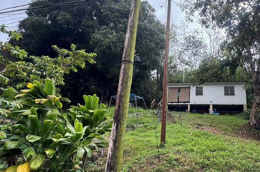 Wooden house with a wood and zinc roof, featuring two bedrooms, one bathroom, living room, dining room, kitchen, and a lot of 2,213.2439 square meters. Located on Road 344, Km. 1.2, Bo. Guanajibo, Hormigueros.