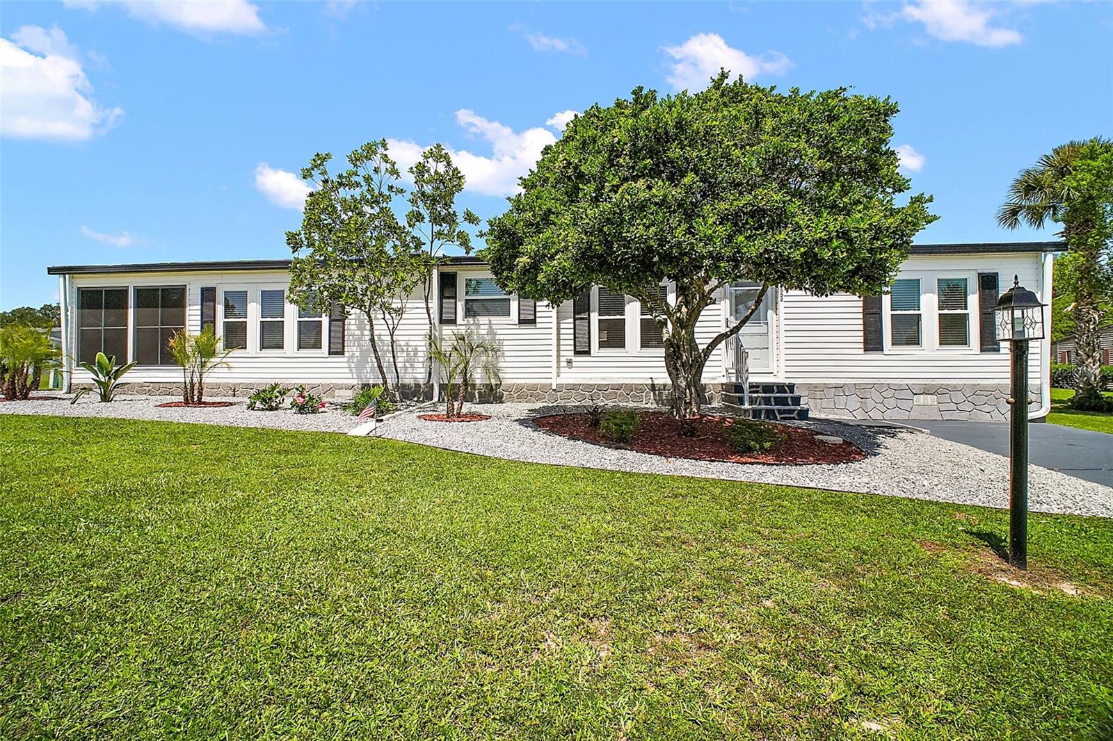 Hilltop Estates, a premier 55+ community where YOU OWN YOUR LAND!! no lot rent! This immaculate 3/2 Palm Harbor home is 1,554 sq. ft.
is fully updated and move in ready. Step into the spacious great room with soaring ceilings, chair railing and crown molding, where the living and dining room areas blend beautifully. Featuring Roof 08/23, Double Hung Tinted Windows 12/2023, 2 year old water heater and A/C compress and heat pump, Luxury vinyl floors, this home combines quality and comfort. The kitchen has new updated cabinets, new sink, and pull out drawers in the cabinets. You will enjoy your eat in kitchen that looks over your fabulous landscaping. The Primary Bedroom has a walk in closet. En-Suite is gorgeous, completely updated! Enclosed laundry room with washer and dryer. Utility room off the carport. Huge Lanai with new vinyl windows and screens. This gorgeous home has parking for 4 cars, and is newly painted. Refrigerator in the photo will not convey. There will be a replacement refrigerator.
HOA FEE is $130.00 a month, includes: Water, Trash, Sewer, Community Pool, Jacuzzi, Club House, Pickle Ball Court, Shuffle Board, RV Parking Lot, maintenance of the common grounds.
Walking distance to The Villages where you can enjoy: The V.A. Restaurants, Grocery Store, Nail and Hair Salon, Drug Store, Doctors Offices AND Lots More! This home is move in ready and waiting for you!!! Please book your tour today!!!
