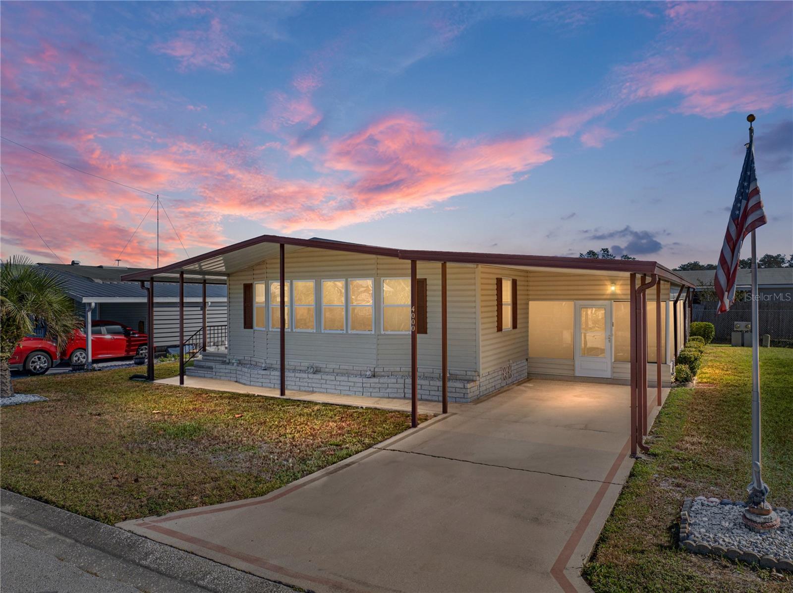 You own the land in this amenity-filled 55+ community!! Located right across from the clubhouse, this spacious 2 bedroom, 2 bath manufactured home is now available and is being sold fully furnished. Arrive to a 1 car carport, and an enclosed side porch that creates a warm welcome to the property. Inside, the living and dining rooms are combined, providing an open entertaining space highlighted by vaulted ceilings, built-in storage, and abundant natural light. The kitchen is nicely equipped with a 4 piece appliance package, pantry storage, and a breakfast bar. Both bedrooms are generously sized and have walk-in closets! The primary bedroom has its own private ensuite, and there is a full bathroom in the hall for guests. A convenient laundry/storage room with a 2023 washer and 2024 dryer is accessible through the enclosed porch as well! AC 2011, Water Heater 2011, Membrane roof 1995. Enjoy the outdoors from your back patio or stroll across the street and take advantage of your access to the clubhouse, swimming pool, spa, shuffleboard, and tennis courts. Colony Hills is a centrally located Zephyrhills community with a low HOA fee and easy access to local shopping, restaurants, medical facilities, highways, and more! Call us today for your private viewing.