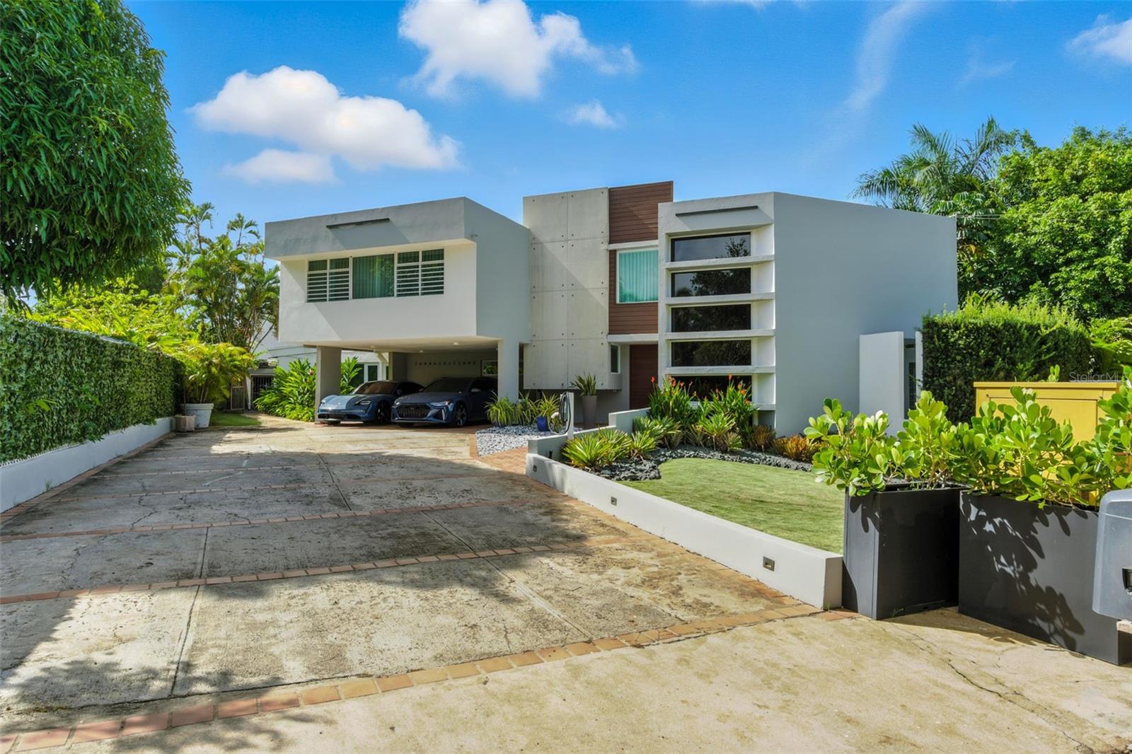 Modern Tropical Elegance in Garden Hills Norte – A Private Oasis in the Heart of Guaynabo
Located in the sought-after, guard-gated community of Garden Hills Norte, this extraordinary residence perfectly blends tropical modern architecture with the comforts of high-end living.
Renowned as one of the most exclusive neighborhoods in the metropolitan area, Garden Hills Norte offers unmatched privacy, 24/7 security patrols, and a strategic location that bypasses major traffic routes while keeping you near the best schools, dining, and shopping.
Tucked at the end of a tranquil cul-de-sac, this 4,200 sq ft home sits on an expansive 1,200 m² lot and offers a true resort-style lifestyle in the privacy of your own backyard.
? Key Features:
4 generously sized, remodeled bedrooms, including an expansive primary suite with a spa-like bath and walk-in closet
5 full bathrooms, including a dedicated full bathroom by the pool
Newly remodeled designer Chef kitchen featuring high end VIKING appliances, Quartz countertops, a wine bar, coffee station, and integrated sound system
Grand living spaces with floor-to-ceiling windows for natural light and indoor waterfall wall for zen ambiance
Formal dining room and a separate spacious family room ideal for entertaining
Comfortable laundry area with brand new washer and dryer appliances
Smart Home technology with Ring app integration for alarm, lights, appliances, and solar-powered cameras
Smart gate and smart irrigation system for ultimate convenience
Brand new hurricane-resistant windows and doors on the first floor
40 solar panels with 3 Tesla Powerwall batteries + 25KW Caterpillar diesel generator = unmatched energy independence (Lease pays $547 but you only pay $4 a month to Electricity company LUMA)
NEW Solar Water heater w 3 panels
NEW EV Charger already in place
Covered 2-car garage plus driveway space for 6 vehicles
NEW Roof Sealant treatment with 25-year warranty
?? Your own private Outdoor Resort Style Oasis:
Saltwater pool & Jacuzzi with marble finish, heater, and inverter motor
Covered concrete terrace with luxurious wood finish ceiling and outdoor dining area
Full outdoor kitchen with brand new “Bull BBQ equipment” and Paragon louvered pergola for all-weather outdoor enjoyment
Professionally landscaped grounds with smart sprinkler system.
This is not just a home—it’s a statement of lifestyle, design, and peace of mind.
Whether you're entertaining guests or simply retreating into your own sanctuary, this home delivers elegance, comfort, and sustainability in one of Guaynabo’s most desirable enclaves.