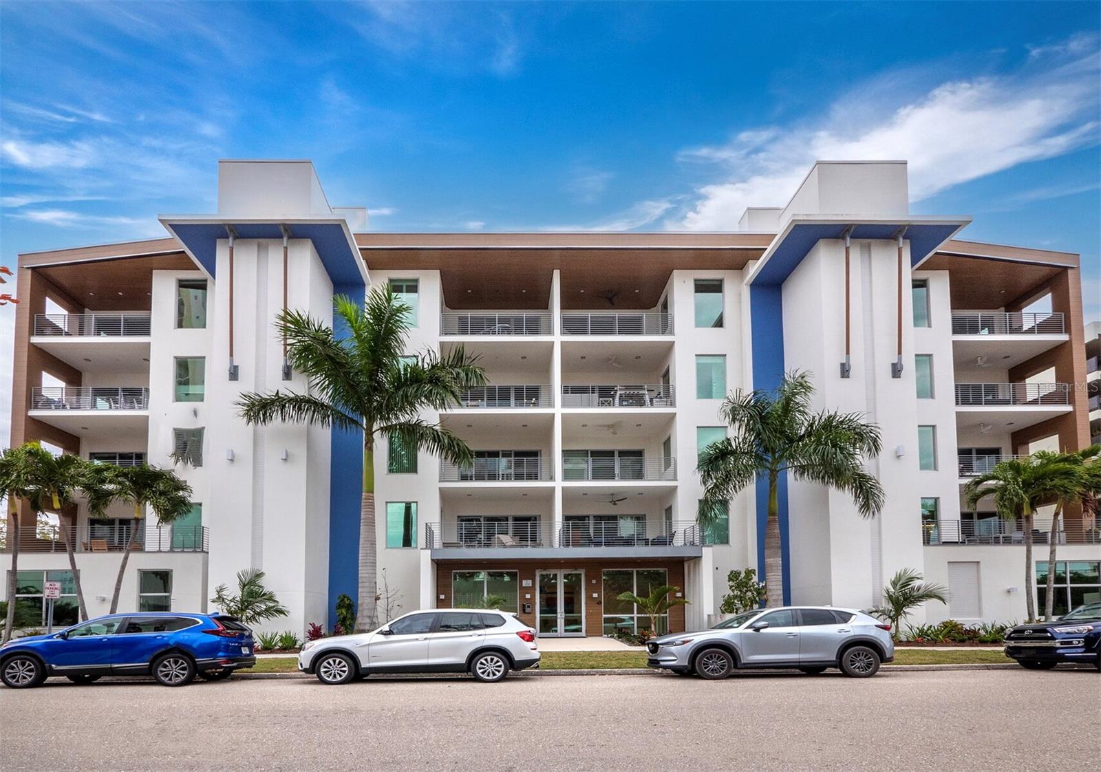Newer construction without the wait in Downtown Sarasota at the ideally located 7 One One Palm.
Nestled beside the bayfront in Downtown’s most desirable tree-lined neighborhood, this 3-bedroom, 3-bath corner penthouse boasts panoramic views of the Ringling Bridge and Sarasota Bay, with abundant natural light, 11-foot ceilings, premium-quality modern finishes, and luxury upgrades throughout.
Beyond the semi-private elevator entry, chic interior features showcase contemporary luxury with clean angles, sleek surfaces, and a harmony of stone and wood tones that enhance the dramatic views, from the residence and the spacious west-facing terrace. The home’s open plan features a welcoming entry, spacious dining area, and easy flow to the great room and kitchen, which boasts Italian cabinetry, side-by-side refrigerator, double wall ovens, Bosch 5-burner gas range, Hansgrohe fixtures, and a large island with Caesarstone countertop.
The spacious owners' suite is a bright and airy oasis, offering double walk-in closets with built-in wardrobes and a large ensuite with an oversized glass-enclosed shower, dual floating vanities, linen cabinet, and a separate water closet.
One of the two guest suites is outfitted with a custom shelving system that contains a queen-sized Murphy bed; the second guest suite features a built-in California Closets office setup, creating the perfect transitional space for both a home office and occasional guests. A dedicated laundry room adds versatile function with built-in cabinetry, full-size stack washer/dryer, and a laundry sink. Additional upgrades in this residence include custom-painted 8-foot solid core doors, water filtration and automated shades with smart home integration. Two dedicated garage parking spaces, bicycle racks, and secure air-conditioned storage ensure even more convenience.
With a boutique scale of only 16 exclusive residences and an intimate sense of community, 7 One One Palm is the ideal urban retreat in Downtown Sarasota. Resort-style amenities include part-time concierge, the private Palm Terrace with oversized pool, spa, cabanas and firepit; fitness facility, package room, and a convenient ‘paw park’ for resident pets. The picture-perfect address is at the heart of Sarasota’s cosmopolitan amenities, within steps of the farmers market, Whole Foods, shops, restaurants, and boutiques as well as renowned cultural enterprises; the serenity of the beaches and convenience of Sarasota Memorial Hospital, SRQ Airport, and much more are minutes away.