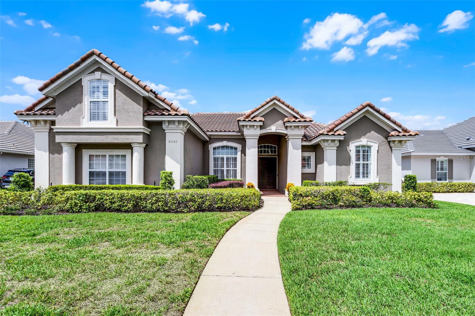 Experience luxury and thoughtful design in this extensively renovated and fabulous 5-bedroom, 4-bath custom Reiche Silliman home, nestled in the prestigious gated community of Kensington Park in the heart of Dr. Phillips. Classic curb appeal features a tile roof, manicured landscaping, and elegant plantation shutters. The side entry 3 car garage and the driveway have ample space for families with multiple cars. Step inside the spacious foyer, and notice the efficient use of space in this open floor plan and coupled with a smart home system for the home to provide the lifestyle today’s families want and need. There is dedicated home office just to the left of the entry with a front view where you can watch for your package deliveries while you work. Also adjacent to the foyer is Bedroom 4, complete with a full bath next to it for perfect privacy for guests or multigenerational living. The open-concept living area dazzles with oversized tile floors, designer lighting, and stacking glass patio doors that slide into wall recesses seamlessly blending indoor and outdoor spaces to the screened lanai, pool, spa, and sun-filled patio. The chef’s kitchen has been reconfigured, expanded and striking upscale finishes chosen to create the home’s warm and inviting heart of the home, featuring a 6-burner gas cooktop with stainless steel exhaust above, two walk-in pantries and plentiful cabinetry, a large center island with lots of prep space for multiple cooks to work, and which has custom roll-out shelving with heavy-duty hardware. There is a separate breakfast bar with deep stainless farmhouse style sink, pendant lighting above and it overlooks the spacious family room with built in shelving and cabinets around the gas fireplace. Entertain with ease in this home with the open dining room area with lots of space for seating around your large dining table and the handy built-in bar and server. This home is perfect for gatherings big and small. All of the bedrooms in the home have beautiful wood floors for a warm and inviting look. The primary suite is privately located on the main floor, offering a spa-inspired bath with a soaking tub and walk-in shower, double sink vanity, two generous sized walk-in closets, and private toilet room—all the makings of a serene retreat after a busy day. The primary bedroom overlooks and accesses the pool and patio through glass patio doors. Bedrooms 2 and 3 are tucked down a hallway on the opposite side of the home, along with a full bath with stunning new walk-in shower, that also serves as a pool bath, ideal for kids and guests. Upstairs, a generous fifth bedroom or bonus room with its own full bath and closet is the perfect retreat for teens, guests, a home gym, or a movie and game area. The updated laundry room location is handy right next to the kitchen and features a deep utility sink, ample cabinetry, and a modern ventless stacked washer/dryer for added convenience. Kensington Park has a playground, tennis basketball and pickle ball courts in the community park just inside the entry gates. Located minutes from top-rated schools, many varied grocery options, upscale dining, boutique shopping, and Orlando’s best attractions, this home combines luxury, privacy, and everyday ease in one of the city’s most desirable neighborhoods.