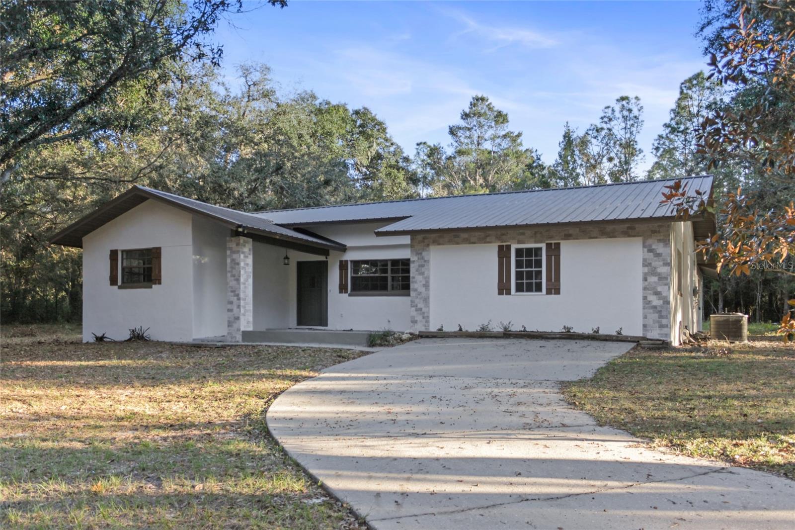 Discover the perfect home to enjoy peace and tranquility, surrounded by nature and the beauty of majestic trees on an expansive 2.73-acre lot. With almost 2,000 sqft of living space, this charming 3-bedroom, 2-bath home offers all you need to embrace serene living. This property provides an unmatched sense of peace like no other place, offering extreme privacy with its secluded location. The home features a spacious laundry room with a washer and dryer, as well as a detached garage that can be used as storage or transformed into a man cave. The interior boasts tile flooring throughout, an upgraded kitchen with a large breakfast island, and modern appliances. Both bathrooms have been recently updated, providing a fresh and contemporary feel. Enjoy the convenience of a private gated entrance, adding security and exclusivity to the property. Located in the picturesque Ocklawaha area, this home offers easy access to Lady Lake Commons and other major retail centers for shopping and dining. Don’t miss this opportunity to experience nearly 2,000 sqft of comfort, surrounded by 2.73 acres of natural beauty and extreme privacy!