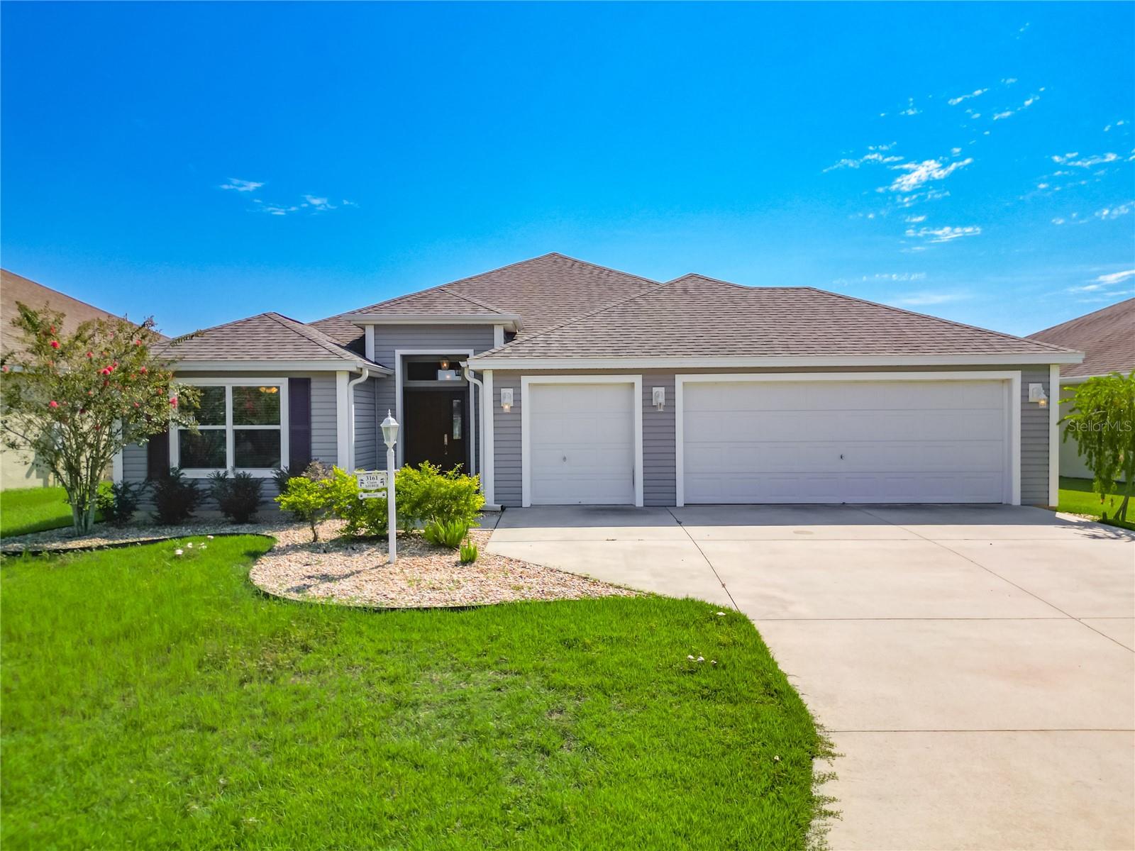 This well-maintained, one-owner home offers 1,908 sq ft of open living space in the highly desirable Village of Pine Ridge. The popular split-bedroom layout is designed for both everyday comfort and entertaining. Inside, you’ll find tray ceilings in the primary suite, an enclosed lanai with its own A/C and electric sun shades, and a laundry room with utility sink and cabinetry. The kitchen features stainless steel appliances (only two years old), a spacious pantry, and plenty of counter space. The primary suite includes a walk-in closet, dual sinks, and a Roman-style walk-in shower, creating a private retreat within the home. The guest wing is set apart at the front of the house, with two bedrooms and a full bath with tub/shower combo, offering privacy for visitors. A two-car plus golf cart garage provides ample room for vehicles, storage, and your cart for quick trips around the neighborhood.
Conveniently located near Colony Plaza Shopping Center and Colony Cottage Recreation Center with its sports pool and activities, this home is also centrally positioned between Brownwood Paddock Square and Lake Sumter Landing. That means easy access to dining, shopping, entertainment, and nightly live music. The Villages lifestyle offers more than 50 golf courses, 100+ recreation centers, and thousands of clubs—everything from pickleball and bocce to woodworking, gardening, and dancing. You’ll also enjoy scenic walking trails, dog parks, adult and family pools, and countless social events.
Move-in ready and thoughtfully cared for, 3161 Dressendorfer Dr blends comfort, style, and a prime location in the heart of The Villages. Schedule your private tour today.