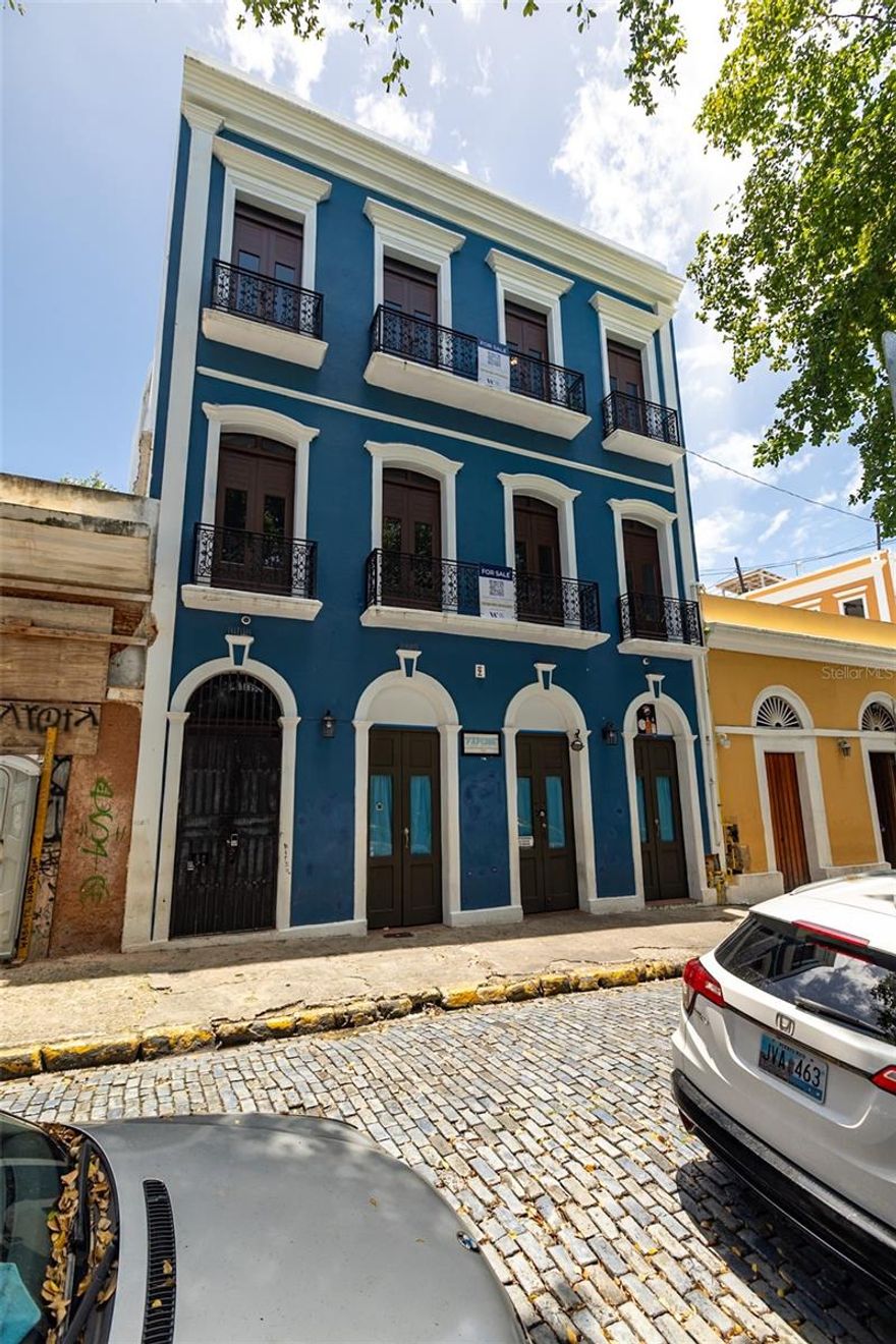 Here’s your chance to own a slice of history! Own your very own century-old gem, nestled in the 500-year-old heart of Old San Juan. No other property compares, and the location is unparalleled. Positioned on a serene side street, it’s mere steps from the renowned Calle San Sebastián and the Catedral Basilica de San Juan Bautista, the oldest church in the Americas. From the largest private rooftop in the area, savor unobstructed views of Castillo San Felipe del Morro, the fortress that shielded Puerto Rico for centuries, with sunsets to marvel at year-round, this incredible property is producing an 11.9% cap rate at the current asking price. To the north, behold the waves crashing against the colorful, historic shanty town of La Perla. To the east, watch cruise ships dock and depart daily, gliding past you. The building consists of 3 total units allowing you to live in one and rent out the others, or rent all three. This exquisite masterpiece, restored to its original magnificence, is truly one of a kind.