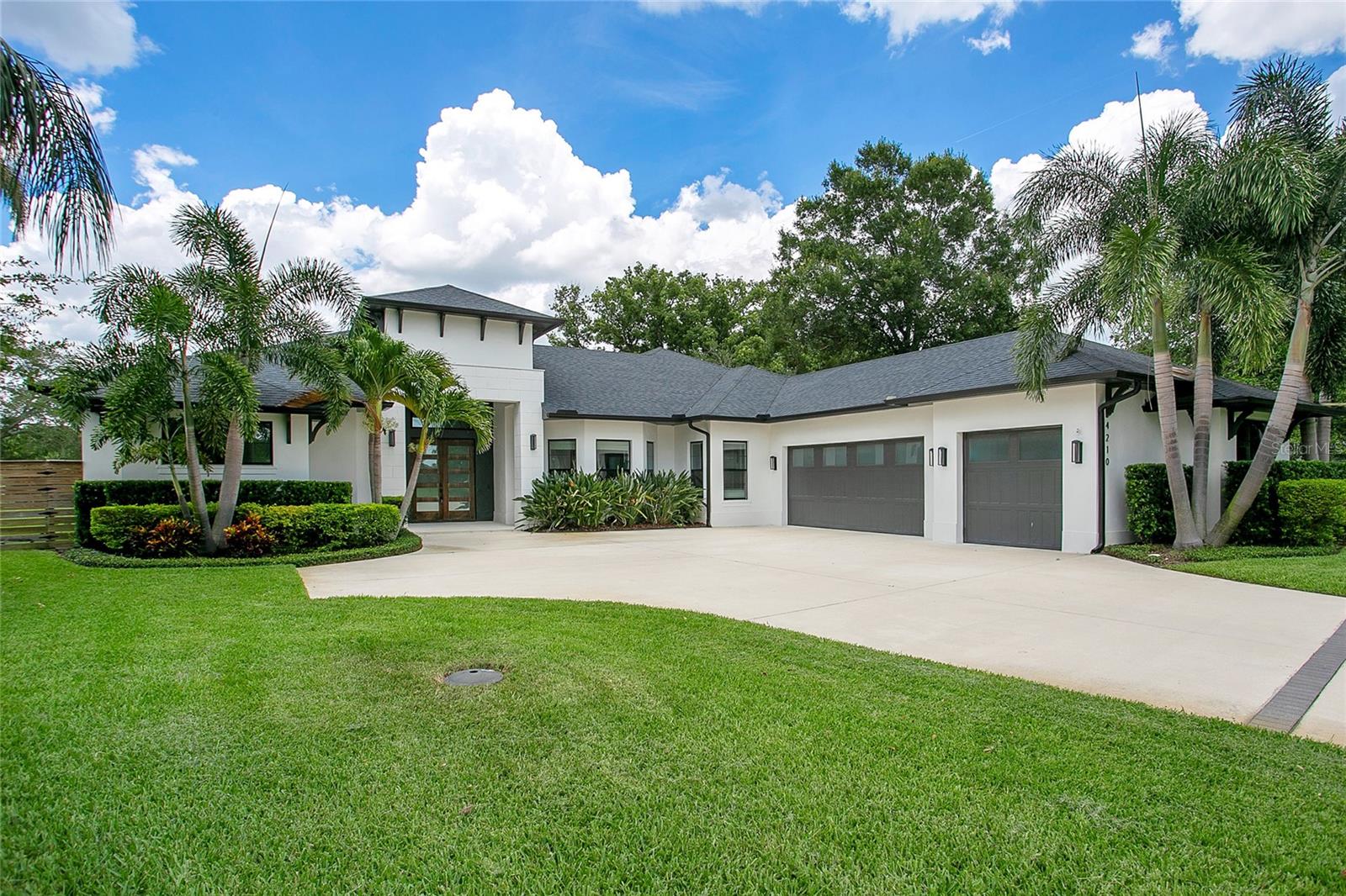 Under contract-accepting backup offers. Some homes are built to stand out. Others are designed to settle you in. Here, you get both. Set on a quiet, dead-end street along the Conway Chain of Lakes, this custom-built saltwater pool home brings together architectural clarity, everyday ease, and a waterfront backdrop that never gets old. With 4 bedrooms, 4 full bathrooms, a 3-car garage, and a detached office, the layout feels expansive without overreaching — grounded by clean lines, volume where it counts, and private spaces that support real-life flow. The exterior sets the tone: modern but warm, framed by mature palms and a front entry that draws you in with intention. Inside, the foyer opens to a central living room — a quiet anchor at the heart of the home. From there, the layout unfolds toward the kitchen and family room, where pocket sliding doors disappear into the wall and the indoors spill effortlessly into the outdoor living space. The oversized island takes center stage, overlooking the family room and pool beyond — it’s where homework gets done, meals get made, and guests tend to linger. Just behind it, a hidden butler’s pantry keeps everything in its place — generous in size, functional by design, and tucked completely out of view. The bedrooms are each set in their own corner, offering privacy and flexibility. Two guest suites feature full private baths, while the third shares a nearby full bath. The primary suite spans the entire left wing — quietly set apart with a wall of windows, dual walk-in closets, direct pool access, and an ensuite that makes a statement without saying too much. A freestanding tub sits behind frameless glass, sharing space with a double shower and dual rainfall showerheads. Separate vanities and clean finishes keep the mood soft, balanced, and quietly luxurious. Even the laundry room gets it right — with custom cabinetry and a built-in dog wash that simply makes sense. But where this home truly settles into its identity is out back. Clean lines give way to open sky, water views, and a stretch of green that rolls gently to the lake’s edge. A saltwater pool and spa sit at the center, framed by a covered patio and geometric stepping pads — a space where conversations run long, the sunsets land softly, and the outside feels like part of the home. It’s quiet here. Intentional. The kind of yard that feels like a privilege to care for. Zoned for A-rated Pershing K-8 and Boone High School (Go Braves!). Tucked away, yet fully connected. Minutes to the airport, local shops and dining, and just a short ride to downtown — without ever feeling close to the noise. Everything about this home is exactly where it should be — in proportion, in placement, and in how it makes you feel when you walk through the door.