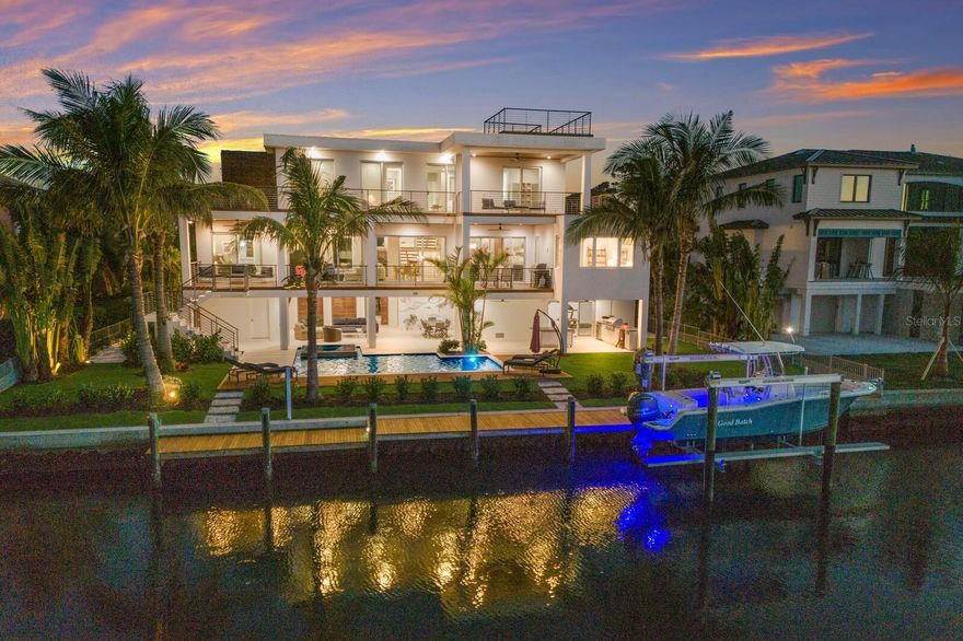 Discover unparalleled luxury and design at 581 Kingfisher Lane, a 2019 masterpiece by Ross Built Construction, this like-new, move-in-ready home is ideally located in Longboat Key Estates, offering direct access to Sarasota Bay and just seven homes from the pristine Gulf beaches. This home combines the best of coastal beauty, modern design, and convenience, offering a perfect retreat for those seeking both relaxation and adventure. Situated on a deep-water canal, the property features a 60’ two-tiered dock with a new 10-ton boat lift, providing immediate access to the Intracoastal Waterway, and Sarasota Bay. Enjoy sweeping 360-degree views from the private rooftop observation deck, an ideal spot for watching sunsets or simply relaxing. The expansive outdoor space includes an outdoor kitchen, pool, and spa, creating an entertainer’s dream. Additionally, the HOA-owned private-access beach on the Gulf is equipped with a pavilion, perfect for a beachside escape. Located adjacent to LBK’s Bayfront Park, residents can take advantage of public amenities such as tennis and pickleball courts, fishing docks, dog parks, and a community center. Inside, this Organic Modern home spans 3,925 square feet and blends natural materials like tongue-and-groove cypress, walnut, Brazilian ipe, and Turkish shell stone, creating a warm and inviting atmosphere. The open-concept layout features minimalist designer finishes and premium appliances from Wolf, Cove, and Sub-Zero, ensuring the highest quality and functionality. Each of the four en-suite bedrooms offers privacy and comfort, with two master suites designed for ultimate relaxation. The clean lines and sophisticated finishes throughout enhance the home’s refined elegance, making it a true sanctuary. The home’s thoughtful design and efficient layout are perfect for both intimate living and large gatherings, making it as functional as it is luxurious. Meticulously maintained, this home offers the ultimate in waterfront living, combining modern architectural design with the relaxed coastal lifestyle of Longboat Key. Whether you’re boating, lounging by the pool, or enjoying the beach, this home provides the perfect setting for those who appreciate high-end finishes, breathtaking views, and a prime location.