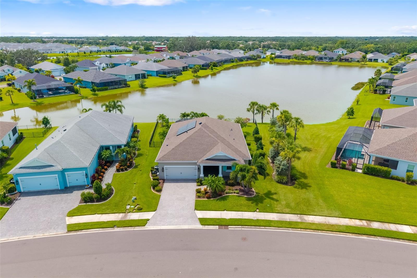 One or more photo(s) has been virtually staged. Welcome to the highly desirable, gated community of Canoe Creek, where resort-style amenities meet modern elegance. Situated on an oversized, fenced lakefront lot, this meticulously upgraded residence offers a rare combination of privacy, space, and luxury. As you step through the front door, you're welcomed by an open-concept layout featuring tile flooring throughout, 10-foot ceilings, crown molding, and 5" baseboards. Having every detail designed with comfort and style in mind. The split floor plan provides separation between the two spacious bedrooms and a private office that easily functions as a third bedroom or flex space. At the heart of the home, the chef’s kitchen boasts granite countertops, upgraded soft-close cabinetry, stainless steel appliances, and a massive island perfect for hosting and everyday living. The kitchen flows seamlessly into the expansive living area, creating an inviting space to entertain. The primary suite is a true retreat, offering dual walk-in closets, a spa-inspired walk-in shower, and dual vanities. Slide open the glass doors and step outside to your extended screened lanai with epoxy flooring, where you’ll enjoy breathtaking lake views in total serenity. Additional features include , two-car garage with epoxy flooring and extended storage/workshop space, paver driveway and front patio for enhanced curb appeal, paid-off solar system for maximum energy efficiency, house generator with hook-up, reverse osmosis water filtration system, and plenty of room to add a pool. Enjoy all that Canoe Creek has to offer including resort-style pool, clubhouse, fitness center, dog park, tennis & pickleball courts, and a true sense of community all with low HOA fees and easy access to I-75, shopping, and dining in Parrish, Lakewood Ranch, and beyond. This lakefront gem is the complete package, schedule your private tour today!