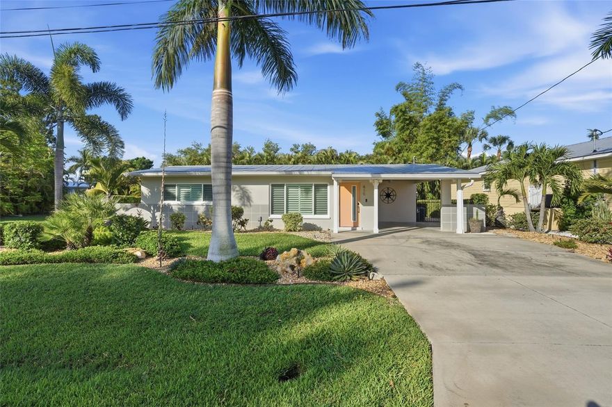 This gorgeous, sun-drenched mid-century modern home sits in the heart of Punta Gorda’s Historic District. From the moment you arrive, the charming bungalow draws you in with its clean mid-century lines, a perfectly chosen gray palette, touches of tropical flair, and beautifully curated landscaping full of texture and vibrant blooms. Lush palms and tropical plantings surround the property, creating a colorful, almost painterly setting.

There’s truly nothing to do but relax—imagine pouring a cool drink, grabbing a book, and unwinding beside (or in) the free-form pool filled with sparkling blue water. The backyard is just as impressive as the front, offering a private, sensory-rich tropical retreat. Along the west side, a row of mature 20-foot Areca palms sways gently, adding both beauty and seclusion. The space is enclosed by an ornamental metal fence lined with podocarpus and draped in bougainvillea, enhancing the resort-like feel. A large stone paver patio provides plenty of room for dining and enjoying the pool and garden.

A new storage shed offers practical space for tools while also increasing privacy around the pool and entertaining area. A conveniently located half bath is easily accessible from outdoors—perfect for poolside lounging or gardening. The yard even attracts local wildlife like mockingbirds, cardinals, and butterflies, while the distant sound of church bells adds a nostalgic charm.

When you want shade or shelter, retreat to the inviting screened porch, highlighted by a one-of-a-kind salt-washed turquoise wood plank ceiling. It’s an ideal spot for morning coffee or evening cocktails.

Inside, the home continues to impress. The original terrazzo floors have been beautifully restored and polished, making a striking statement. The layout maximizes space efficiently, and the updated U-shaped kitchen features shaker cabinets, new granite countertops, and all new appliances. The dining area comfortably seats six and opens to the porch through sliding glass doors, while the spacious living room sits at the front of the home.

Two generously sized bedrooms are located on the south side, each large enough for king beds. Quiet MinkaAire ceiling fans provide added comfort. The full bathroom has been fully updated with dual sinks and gorgeous decor

Throughout the home, soft Gossamer Veil gray walls are complemented by crisp white trim, modern white doors with brushed nickel hardware, and plantation shutters. Major upgrades include hurricane impact windows and doors, metal roof, updated insulation, electrical wiring and panel with a whole home generator outlet, tankless water heater, and PEX plumbing. The carport also features a tongue-and-groove plank ceiling for added character.

And the location couldn’t be better. With a high walkability score, you’re just minutes from restaurants, farmers markets, Fishermen’s Village, local shops, the ice cream parlor, Gilchrist Park, the library, and Harbor Walk. Life in this charming coastal town offers endless activities.

Don’t wait—homes like this thoughtfully updated mid-century gem don’t stay on the market long. Furnishings will be removed or may be purchased separately. They do not go with the sale home.
