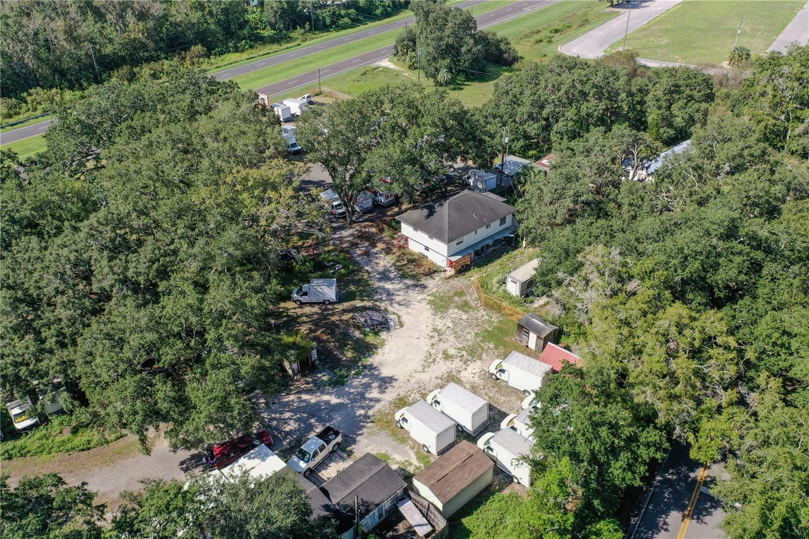 Discover a prime commercial opportunity with this expansive 4.15-acre property, zoned HEAVY INDUSTRIAL (I-2), ideally situated with 575 feet of highway frontage on Highway 17-92 in Lake Alfred. This strategic location offers excellent accessibility to both Tampa and Orlando, with convenient proximity to Interstate 4. The property is fully fenced and cross-fenced for security and features a versatile two-story office building, currently utilized as a business office with a residential space on the upper level. Additionally, a mobile home with added space complements the site. The property includes three septic systems and a 130-foot deep well, ensuring ample utilities for various industrial applications. With room for at least 20 vehicles, this lot is perfect for businesses seeking expansion. Please note that the owner operates a current business on-site. Showings are by appointment only with 24-hour notice—no drop-by's, please. Seize this unique opportunity to invest in a thriving industrial area!