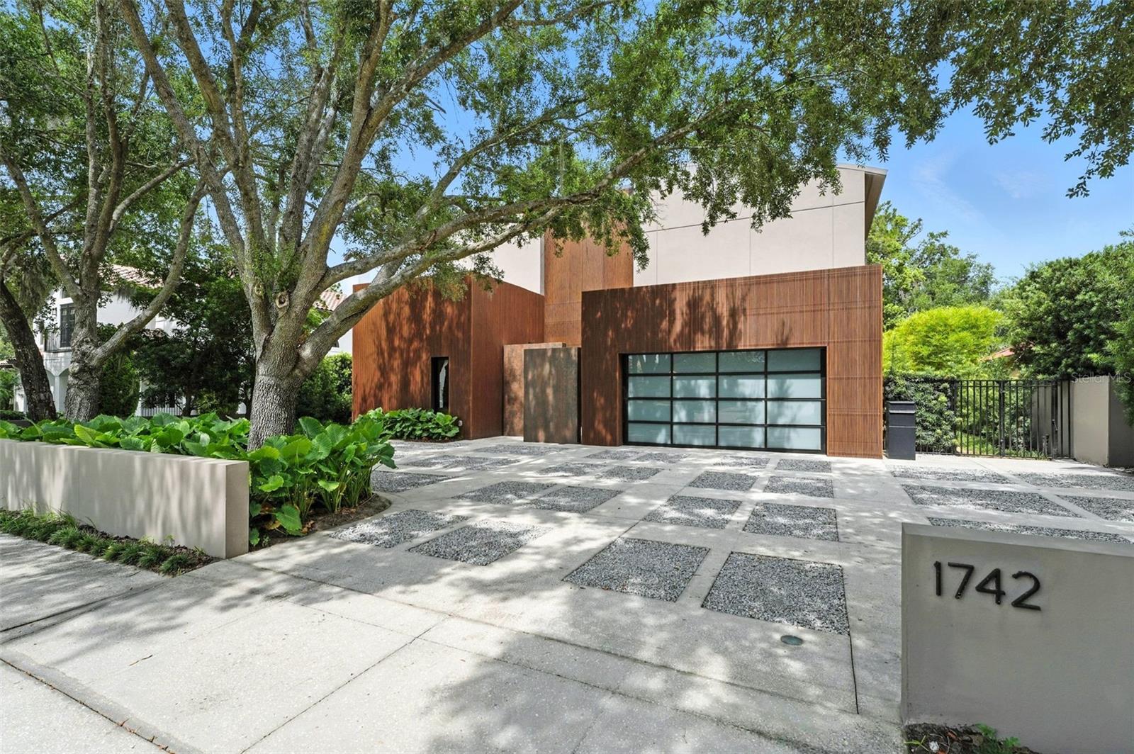 In one of Winter Park’s desirable neighborhoods, this stunning four-bedroom, five-bath modern masterpiece with Control4 automation offers a blend of luxury and function. Designed with sleek lines and open-concept living, the home showcases Italian engineered wood flooring throughout, creating an elegant yet inviting atmosphere. Expansive windows flood the interiors with natural light, seamlessly connecting to the private outdoor oasis. At the heart of the home lies the chef’s kitchen, thoughtfully appointed with hidden storage, light-toned wood-look melamine cabinetry, sintered stone countertops, and premium Sub-Zero and Wolf appliances. Each bedroom is an en suite featuring spacious walk-in closets with custom stone shelving and Melamine finishes, while the baths are adorned with custom-made vanities, stone countertops and mirrors enhanced by indirect lighting. The backyard retreat is a tranquil haven with lush landscaping, a heated mini-pebble French gray swimming pool, and an outdoor barbecue area clad in sintered stone with an integrated grill and sink, ideal for relaxing or entertaining. Additional highlights include epoxy-finished garage floors with a metal-framed glass door, a concrete circular driveway accented with salt and pepper gravel, and the security of a whole-home generator. Ideally, a short distance to Winter Park Racquet Club and Interlachen, and just a mile from Park Avenue, this architectural masterpiece is ready to welcome you home. Contact us today to schedule your private showing.