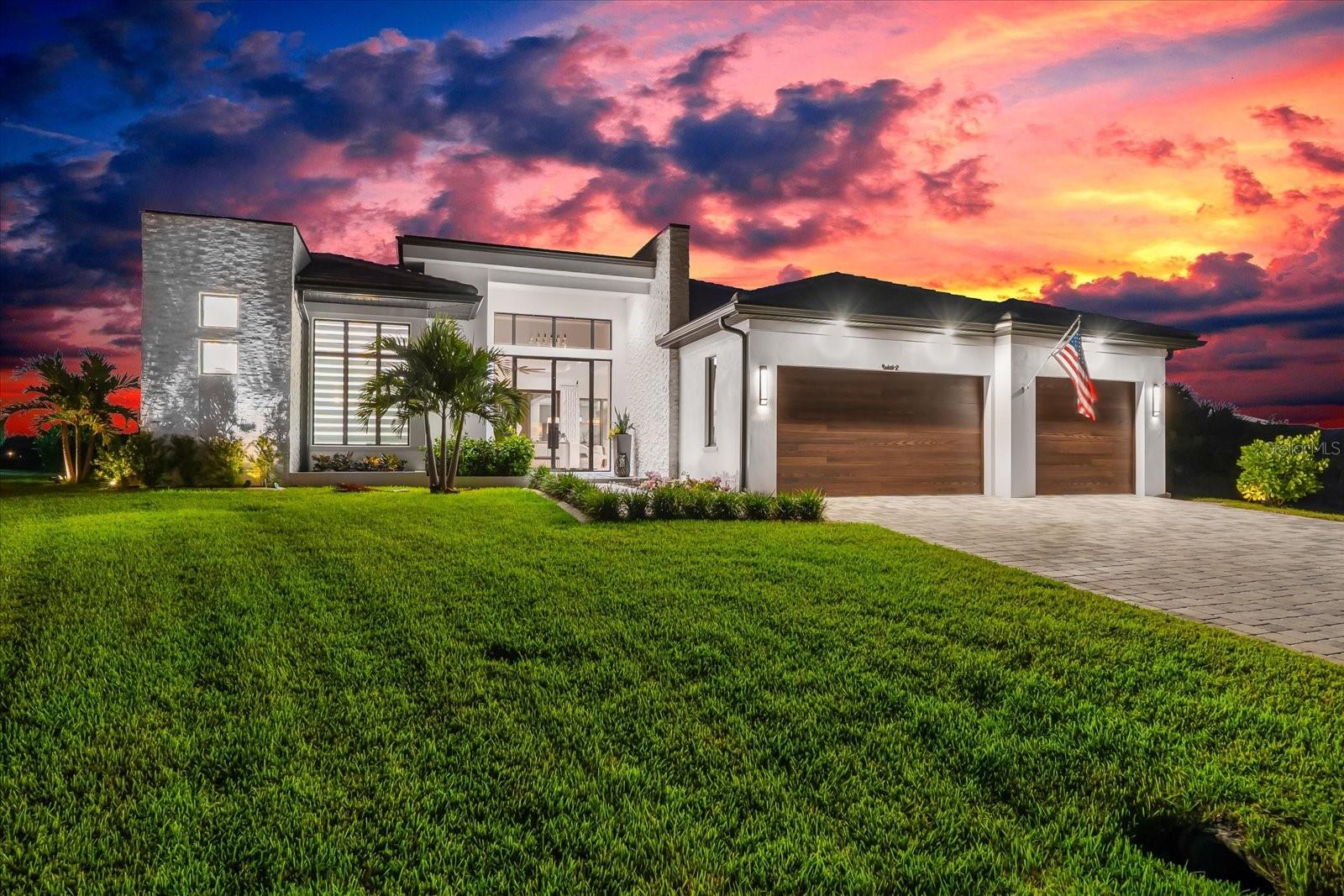 Introducing an extraordinary waterfront residence designed by the renowned Sater Design Group, celebrated for their award-winning designs worldwide. This custom-built soft contemporary home sits on an oversized 0.34-acre lot with stunning intersecting canal views and direct boating access to Charlotte Harbor and the Gulf of Mexico. Offering 2,836 square feet of air-conditioned living space plus 1,648 square feet of unconditioned areas, this home delivers a complete lifestyle experience inside and out. A dramatic glass entryway welcomes you through 10-foot double glass doors with sidelights and a transom window above, setting the tone for the thoughtful architectural details and upscale finishes throughout. The open-concept interior includes three spacious bedrooms, three full bathrooms, and a dedicated office. Soaring ceilings, 8-foot solid core shaker interior doors with Emtek hardware, and PGT impact-resistant casement windows and sliders fill the home with natural light and serene views. The chef’s kitchen features high-end Thermador appliances—including an induction cooktop with vent hood, double ovens, built-in side-by-side fridge and freezer, full-size wine cooler, and under-counter microwave—all integrated into custom double shaker cabinetry with glass display uppers and quartzite countertops. A floating buffet anchors the adjacent dining area, while a large walk-in pantry adds a second Bosch dishwasher, custom cabinetry, and quartz workspaces matching the kitchen and laundry room. The owner’s suite is a private retreat with a spa-inspired bath showcasing a freestanding Jacuzzi tub, glass-enclosed shower under soaring 12-foot ceilings, floating vanities with quartz counters, Kohler sinks, and a Toto Washlet. Built-in drawers feature integrated power and custom organization, and the spacious walk-in closet includes attic access. Outdoors, enjoy a resort-style setting with two large covered lanais—perfect for lounging, dining, or entertaining. One lanai features a fully equipped outdoor kitchen ideal for alfresco meals. A custom-designed pool and spa sit at the heart of the outdoor space, enclosed in a picture-frame cage. The pool features a Caribbean blue pebble finish, elevated interior sections for water sports, a sun shelf, a matching tile spa waterfall, LED lighting, and remote control. Over 1,400 sq ft of tumbled marble pavers in a French pattern surround the pool and outdoor shower area, creating a luxurious and durable entertaining space. The oversized lot is professionally landscaped with decorative rock along the canal edge, lush St. Augustine/FloTam sod, and a full irrigation system fed by canal water. Built for efficiency and durability, the home features 12-foot-high CMU block exterior walls with foam insulation, a flat concrete tile roof, with waterproof membrane, a spray foam-insulated attic with no soffit vents for a sealed system, and an oversized Trane HVAC. A hybrid 50-gallon water heater with heat pump and recirculating system boosts efficiency. Additional features include a three-car garage with epoxy flooring, custom CHI doors, jackshaft openers, and impact-rated service door, plus a charcoal/gray French-pattern paver driveway that enhances curb appeal. This exceptional property offers a rare blend of cutting-edge design, luxury finishes, and direct access to some of Florida’s most desirable waterways. This home must be seen to appreciate.