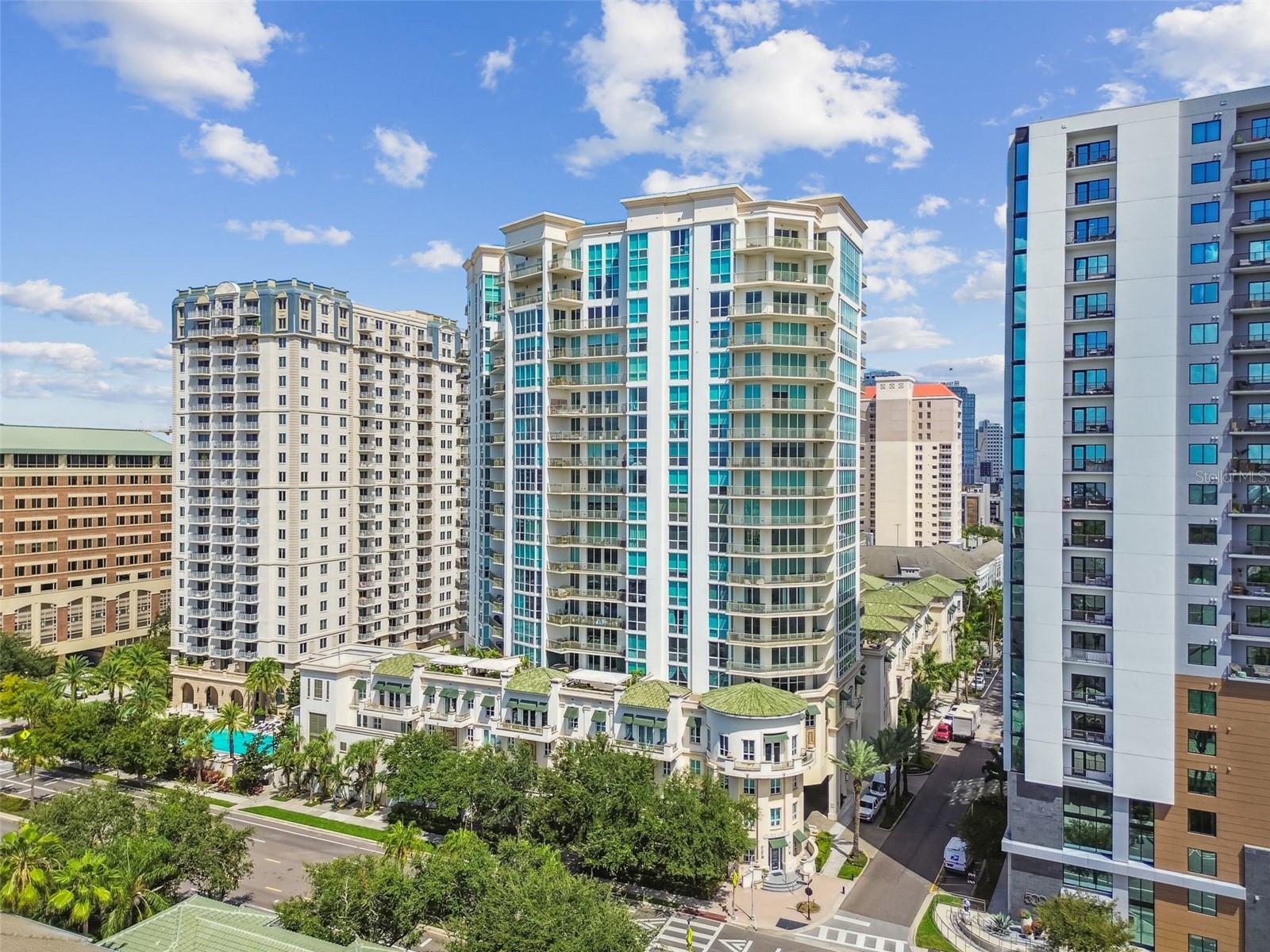 Set on the 5th floor of The Plaza on Harbour Island, this 3-bedroom, 3-bath residence offers the perfect blend of elevated city living and a connected, walkable lifestyle. From its expansive wraparound terrace, enjoy a unique perspective—high enough for sweeping views, yet close enough to feel part of the vibrant Harbour Island community. Inside, natural light pours through floor-to-ceiling windows, highlighting the open layout, modern finishes, and seamless indoor-outdoor flow. The kitchen, fully renovated in 2021, is both stylish and functional with custom white shaker soft-close cabinetry, marble waterfall countertops, and a matching backsplash. GE Café appliances include a 5-burner gas range with hood, microwave/convection oven with WiFi connect, second full-size oven with Wifi connect, dishwasher, wine fridge, and pot filler. A bar-style eat-in counter adds an inviting, casual touch. The primary suite offers a serene retreat with a large bedroom, walk-in closet with custom built-ins, and a spa-like bath featuring a dual-sink stone vanity, walk-in shower, and garden tub. The second bedroom enjoys its own floor-to-ceiling windows, custom lighting, and walk-in closet, with a hall bath nearby offering an extended stone vanity and walk-in shower. The third bedroom includes a private ensuite with a shower/tub combo and stone vanity. A dedicated laundry room with a stackable washer/dryer and utility closet adds convenience. Additional details—solid core doors, tray ceilings, crown molding, recessed lighting, blinds throughout, and built-in fire sprinklers—underscore the home’s quality and comfort. The wraparound terrace, framed by a solid parapet for privacy, offers multiple access points and a water faucet for easy upkeep. Additional updates for owner convenience include new wide plank flooring, AC 2022 and water heater 2014.
Located in The Plaza Harbour Island—one of Tampa’s most prestigious high-rises—residents enjoy resort-style amenities including a heated infinity-edge pool with cabanas, state-of-the-art fitness center, and a beautifully appointed club lounge. The building offers a full-time concierge, 24-hour doorman, valet parking, and private elevator access for select units. All in a peaceful Harbour Island setting, just steps from Downtown Tampa’s best dining, entertainment, and the Riverwalk.