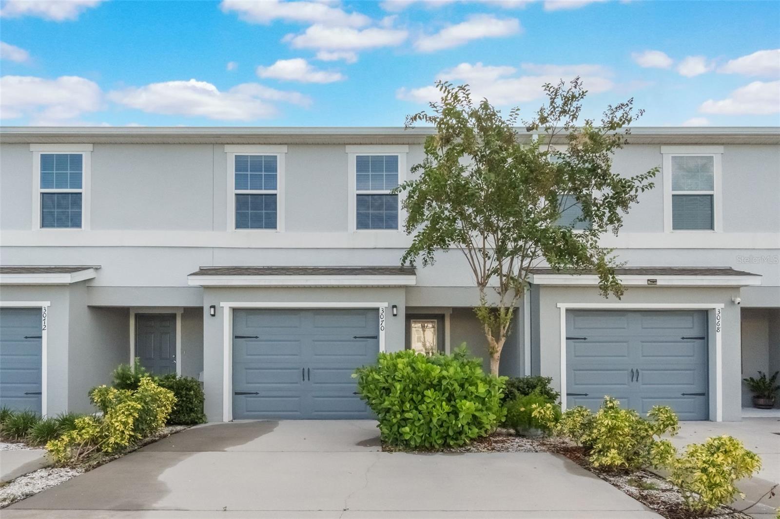 Built in 2021, this move-in ready Gramercy Farms townhome offers modern style and smart design. The open-concept main floor features luxury vinyl plank flooring, a spacious living area, and a kitchen with granite countertops, stainless steel appliances, breakfast bar, and pantry. A half bath, laundry, and storage complete the first level.
Relax on the screened lanai overlooking a wooded nature area with no rear neighbors. Upstairs, the primary suite boasts a custom walk-in closet and en-suite with dual sinks and tiled shower. Two additional bedrooms share a full bath. Attached garage, extended driveway, and convenient location near the Turnpike and Lake Nona make this home an exceptional find.