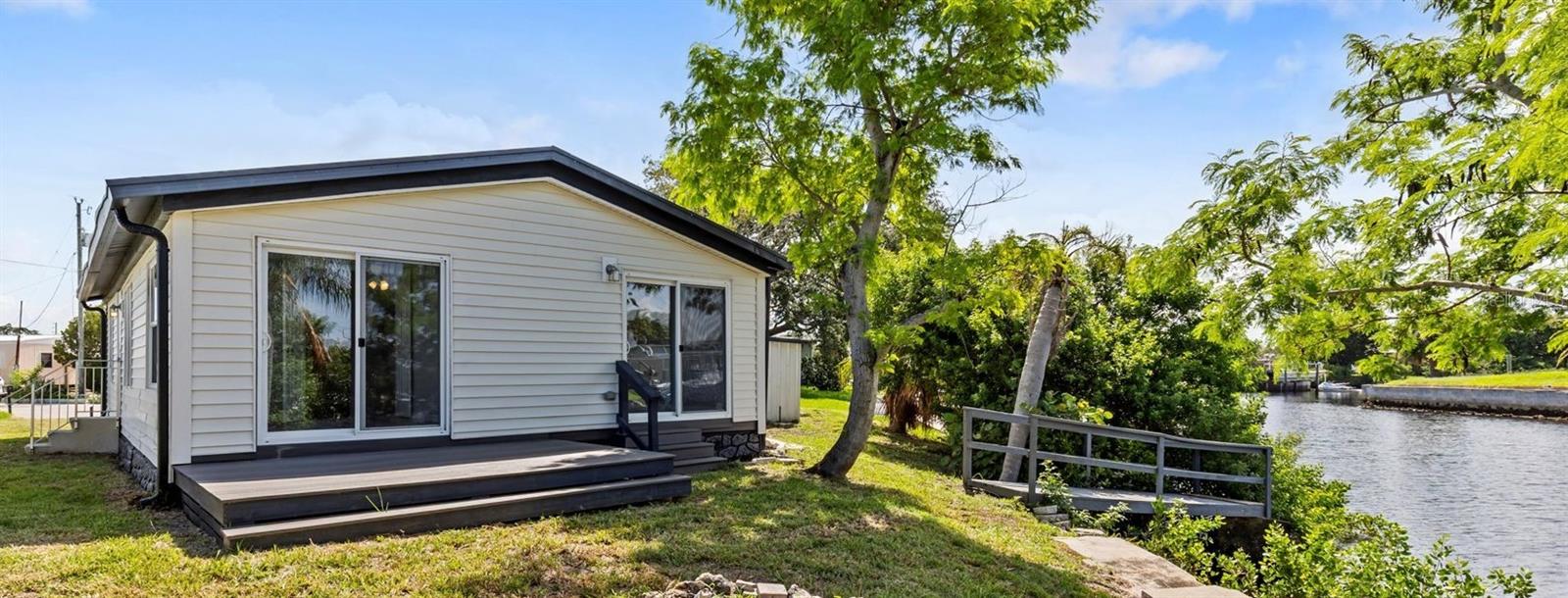 This canal home is on a very deep & wide canal. It's such a great location being just two canals from open, direct Gulf waters w/no bridges! A boater"s dream that you can be out in the gulf in less than 5 minutes!The home is a beautiful, totally remodeled (due to water intrusion) doublewide Manf home with 94 ft on canal water. It's located in a quiet cul-de-sac with breathtaking water views. Due to the distance to the gulf the waters are very clear & dolphin & manatee sightings are not unusual at all verus lower canals. This 3 bedroom, 2 bathroom hm has been professionally remodeled by a licensed contractor. This hm features a pantry, shaker style kitchen cabinets w/granite counter tops. range, microwave, dishwasher & beautiful, new vinyl plank flooring throughout. This open floor plan of Kitchen/living area w/high ceilings provide a spacious feel. The living room features a beautiful electric fireplace for a relaxing ambiance or to warm up on a cooler night. This home features a split floor plan w/the master bedroom on one side & 2 bedrooms on the other side. The master bathroom has two sinks w/granite counter tops & a shower with a fold up seat. Both bedrooms nearest the canal has a sliding glass doors leading to the canal. There is a large 12X8 composite porch to enjoy entertaining or to view those beautiful Gulf Coast sunsets! The 2nd bathroom features a tub/shower. Includes an oversized carport 27X11 that will accomodate 2 cars. 2 shed for storage & a stationary deck overlooking the water. This home features a new A/C & hot water tank & a ‘Standing Seam’ metal roof. Not only is this home less than 5 minutes to the Gulf via boat but before taking the channel to the gulf there is an island & sandbar located within the Signal Cove Subdivision. It is the only island located in Hudson, so it is a local favorite where you can meet up with family, friends, meet the neighbors & bring your pup to play on the sandbar.
In Signal Cove you own the land& home. NO lot fees. NO mandatory HOA fee, just a voluntary fee a year, that allows you access to the private boat ramp. The subdivision has a clubhouse located features many fun events & activities throughout the year & also allows it to be rented for events. This is a golf cart community which often holds Golf cart events & only a few minute cart ride to Hudson beach & local locations such as Sams, Inn on the Gulf, Ollies & Get Hooked among others. We also have scuba west & the Hudson Grotto located just as you leave the community for those scuba divers or those desiring to learn to be one. Signal Cove in Hudson is centrally located to many options for restaurants, shopping, hospitals & doctors. It is only 10 minutes to SunWest Park with its large man made sandy beach & water park that everyone will enjoy. Hernando, Homosassa, Crystal River to the north & many.. locations south such as New Port Richey, Dunedin, Clearwater beach, there is never a shortage of things to do. Tampa & Tampa International Airport are within an hour and Orlando and all the amusement parks can be reached within a 2 hour drive.
Whether you want to make it your permanent or second home, to use it as a weekend get-away, or use it as a vacation rental (because canal homes are always so more desirable), this wonderful property & the Florida, saltwater lifestyle can be yours! Come and check it out! This property is being Sold cash only with valid POF. Buyer and buyers agent to verify all measurements