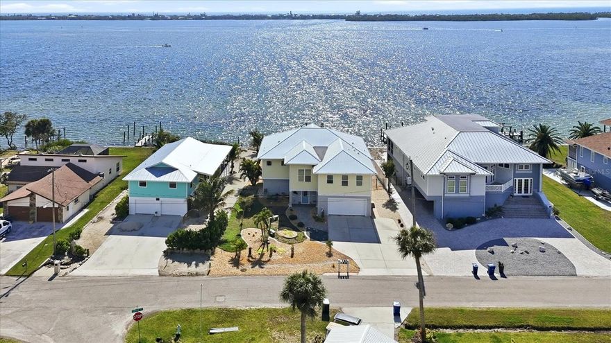 Lemon Bay. Experience breathtaking panoramic Bay views and the ultimate Florida coastal lifestyle from this exceptional waterfront retreat. From sunrise coffee on the expansive balcony to sunset boat rides near your backyard, this remarkable residence captures the magic of Bayfront living. Originally built on ground level and later thoughtfully upgraded, the lower level has been completely renovated with flood-resistant interior walls and automatic flood vents, providing peace of mind and durability. All doors, windows, and sliding glass doors are impact-rated. This level features an oversized garage that accommodates two large vehicles, plus tandem space for a third, along with a workshop area that could easily be converted into additional living space or a guest bedroom. In 2017, an entirely new second story was constructed, creating the primary living area designed to maximize the stunning bay views. The bright, open floor plan features a beautiful gourmet kitchen with stainless steel appliances, quartz countertops, a large island, and custom-built wood cabinetry that seamlessly flows into the dining and living areas. Expansive windows and sliding doors, also impact-rated, frame the magnificent water views and lead to an impressive, covered balcony stretching across the back of the home, a place to relax or entertain while overlooking the Bay. Three spacious bedrooms and two baths, including a serene primary suite with sweeping water views, complete the upstairs, along with a large laundry room with abundant cabinetry for exceptional storage and convenience. An elevator shaft has been roughed in, allowing for easy installation if desired. This amazing property features impact-rated windows and doors, a metal roof, a whole-house water filtration system and tile flooring throughout, among other highlights. Expansive sliding glass doors open to a large, covered balcony overlooking the sparkling saltwater pool and endless water views of the wide-open bay, creating the ideal setting for relaxing or entertaining while enjoying the coastal breeze and amazing sunsets. Boating enthusiasts will love the concrete seawall and existing boat-lift infrastructure with water and electric in place, while the remaining lift components provide a foundation to restore a custom dock and enjoy life on the water. With its elevated modern construction, flexible living spaces, stunning water views and private pool overlooking the Bay, this exceptional property offers the rare opportunity to enjoy the best of Florida waterfront living.