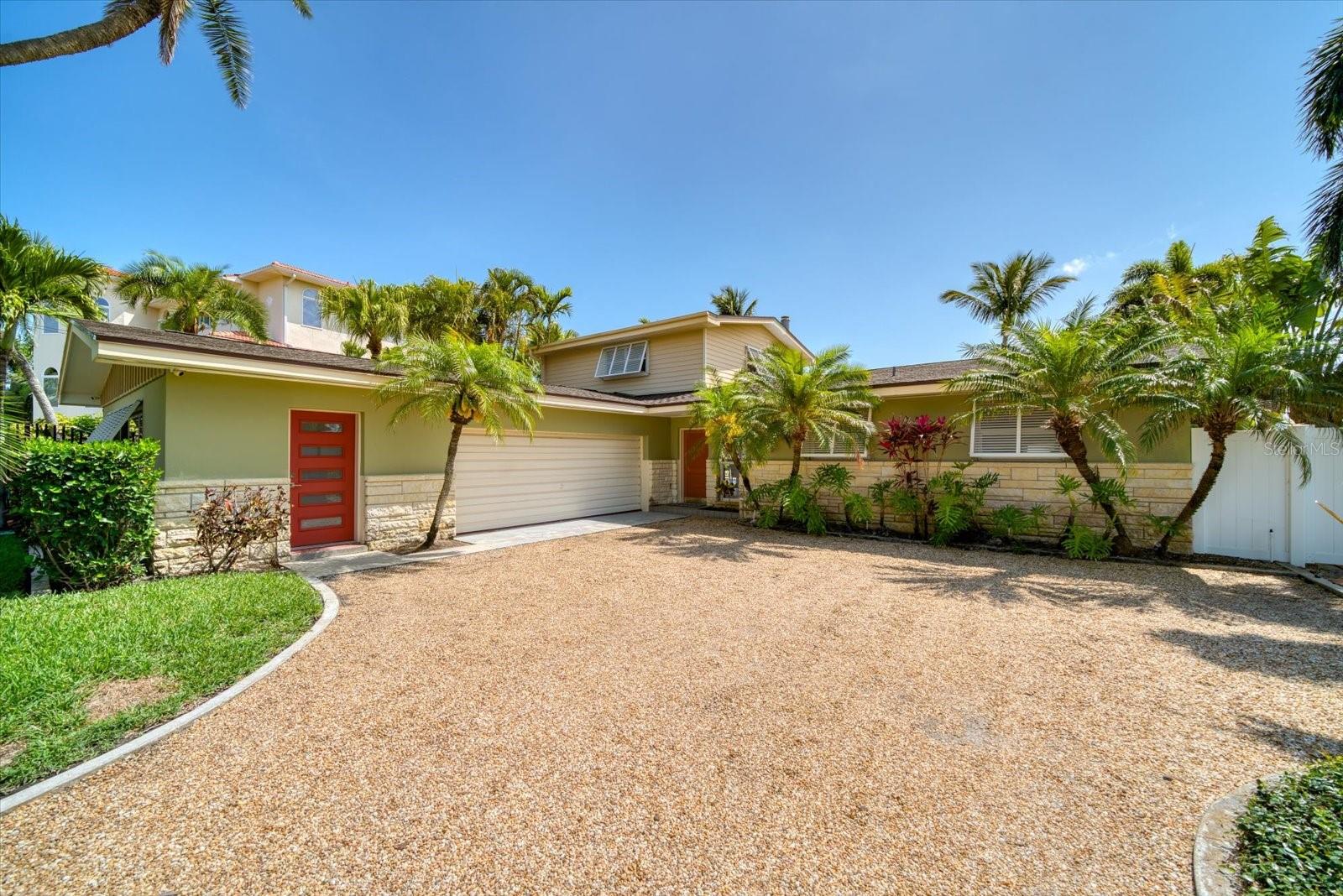 Not just a home, get ready for a new lifestyle. This exquisite property has it all! Upon entering, guests often pause in amazement at the gorgeous wide-open bay vista before them.  Downtown St Petersburg and its iconic skyline seem dazzlingly close, yet distant, making for a magical backyard to be enjoyed from your dock, pool, strikingly attractive great room, or ascend the staircase for astonishing views from a spacious and private primary bedroom. Stunningly remodeled in the kitchen and living areas, the dwelling provides in so many ways. The kitchen features quartz countertops, glass tile backsplash, soft close shaker cabinets/drawers, Samsung refrigerator/freezer and Thor electric range. The open floor plan feels bright, airy and inviting by day, and cozy and elegant by night thanks to chic light fixtures and a new electric fireplace. Expansive pocketing doors across the back of the structure create a spectacular, seamless flow from interior to exterior spaces, making barbecuing or pool-side entertaining pure joy. Enjoy working from your residence in your private office or workshop separated by an oversized two car garage complete with its own entrance. Exterior features include a new shingle roof (April 2023) with 3rd nail on straps, Koi pond and 20K lb. boat lift. The lot is uniquely large for the area at 12,558 sq. ft. allowing for immense enjoyment. Park-like brick paths meander through mature foliage and deliver you to a shaded gathering area and then on to the dock. The 108 ft. of seawall frontage not only improves your view, but allows for more flexibility with your dock placement and size. Having additional depth to the property, provides more privacy, options for expansion, or simply the ability to park an RV. The ample driveway provides an abundance of parking which is rare to find on the beaches. The dock feels like it is on a private lake due to the distant sandbars creating a wake barrier. This makes boarding a boat, jetski or paddleboard easy and safe. Perfect for skiing, tubing or kayaking right from your dock or swimming in tranquility. The views and protected waters are so idyllic you may forget you are gazing upon the Intracoastal waterway which can take you to the Gulf of Mexico and beyond without any drawbridges or slow speed zones. Only one-third a mile from the beach, it is an easy walk, no golf cart required. Whether with your family, or after entertaining, your entire party can leisurely stroll together to the beach, accessing the magnificent sand or enjoying a local favorite, family-friendly bar and grill. Take in the sunset while enjoying one of the many bars and restaurants, toes-in-the-sand optional. Only a short walk to Publix, Starbucks, CVS, and Walgreens among many other conveniences. Tampa International Airport is only 30 minutes away. From stunning, vast views, to location perfection you have found your spot on one of the top beaches in the country. Make your move today!