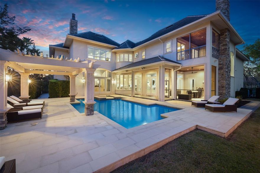 For the discerning buyer who has been waiting for the perfect property, this exceptional European-inspired custom estate is an unparalleled masterpiece. Every detail, from the refined finishes to the meticulous craftsmanship, was carefully curated to offer the ultimate in luxury living. Nestled on a prime, private pond-front conservation lot in The Preserve—within the exclusive, gated community of Hawk’s Landing—this home is a rare gem. With no rear neighbors and located in a NON-FLOOD ZONE, it provides unparalleled privacy and tranquility. From the moment you approach, this magnificent estate commands attention. The circular driveway, complete with a porte-cochère & a gated courtyard containing 4 detached garages and hurricane/safe room/storage, & breezeway attaching to the main home.  The breathtaking façade features custom stonework, a tile roof, copper turrets, medallions, & a stunning cupola, all contributing to the home's incredible curb appeal. The walkway from the circular drive leads you to a grand entrance. Upon entering through the impressive 10-foot wrought iron and glass double doors, you're immediately immersed in an atmosphere of timeless elegance and sophisticated design. Designed for both architectural splendor and exceptional livability, the home boasts an expansive 6,692 s.f., two-level floor plan, featuring four spacious en-suite bedrooms and three half-baths (total of seven bathrooms), a home theater with a wet bar and high-end appliances, & two expansive loft and entertainment areas. The main level includes a richly appointed professional office with custom wood cabinetry, a formal living room, with its dramatic "domical vault" ceiling & fireplace, & elegant dining room, which includes an expansive refrigerated wine cellar. The heart of the home is the remarkable chef’s kitchen, designed to cater to the most refined culinary tastes. Outfitted with top-tier luxury appliances—such as a Thermador Gas Range, and Miele built-in steam oven and espresso machine-- the kitchen also features custom woodcraft cabinetry and stunning oil-finished walnut flooring. The kitchen overlooks a sprawling family room with wet bar (with built-in refrigerated beverage drawers).  Both kitchen and family room are flooded with the natural light that pours through the French doors that line the perimeter of the area and overlook the beautiful resort-like pool, pond and nature’s backdrop.  With every upgrade imaginable, the finishes and features throughout this estate are simply too numerous to list (feature list available upon request). Step outside and experience resort-style living at its finest. The expansive saltwater pool and spa, surrounded by a custom cast stone deck, create the perfect backdrop for relaxation or entertaining. A beautifully designed pergola offers an ideal lounging area, while the screened-in outdoor living room includes an outdoor kitchen, dining space, & a romantic stone-front fireplace with natural gas lanterns. The community of Hawks Landing is situated adjacent to the serene Brooker Creek Preserve, offering residents unparalleled views of lush greenspaces & abundant wildlife. With its prestigious location, meticulously crafted design, and impeccable attention to detail, this property truly embodies the pinnacle of luxury living. No stone has been left unturned—this is a once-in-a-lifetime opportunity to own one of the most extraordinary homes in the area. Don’t miss your chance to experience the epitome of luxury.